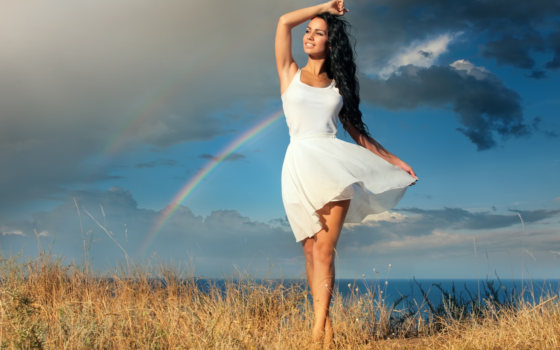 People 1920x1200 women model long hair women outdoors dress smiling sea grass rainbows clouds barefoot outdoors standing black hair sky summer dress looking into the distance arms up