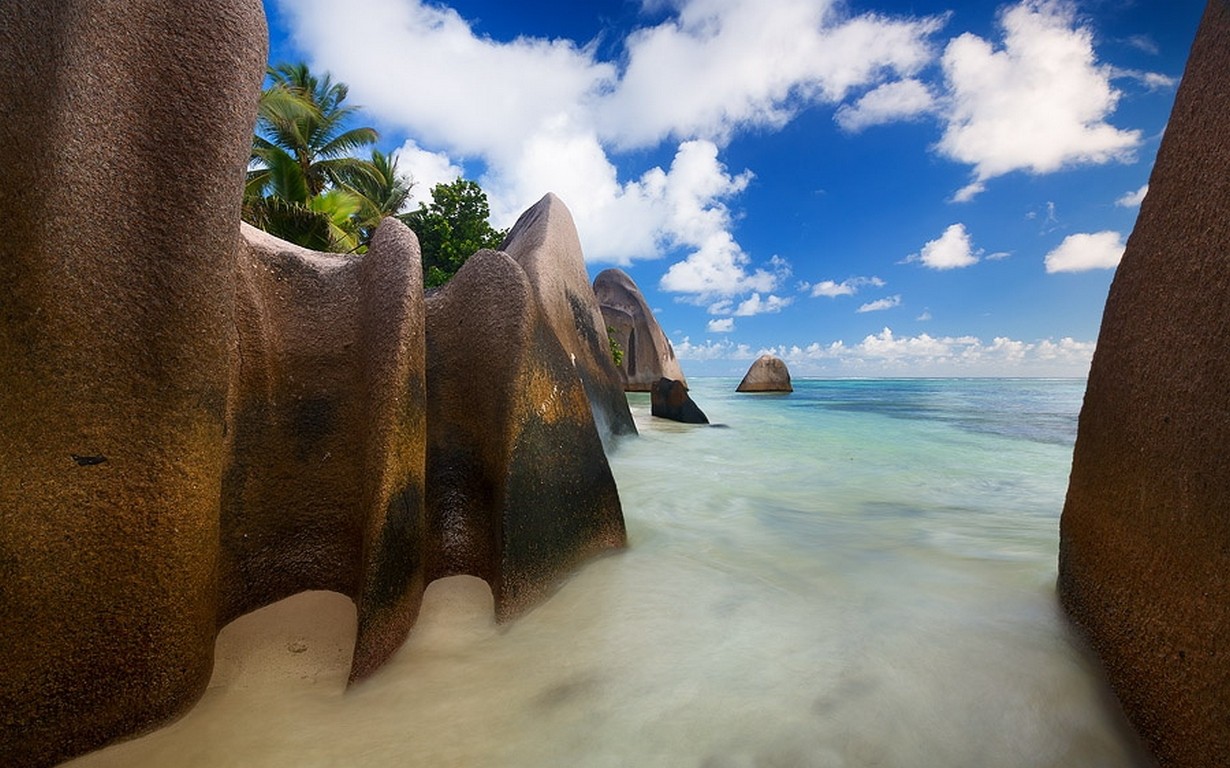 General 1230x768 nature beach rocks clouds sea sand palm trees Seychelles island tropical summer