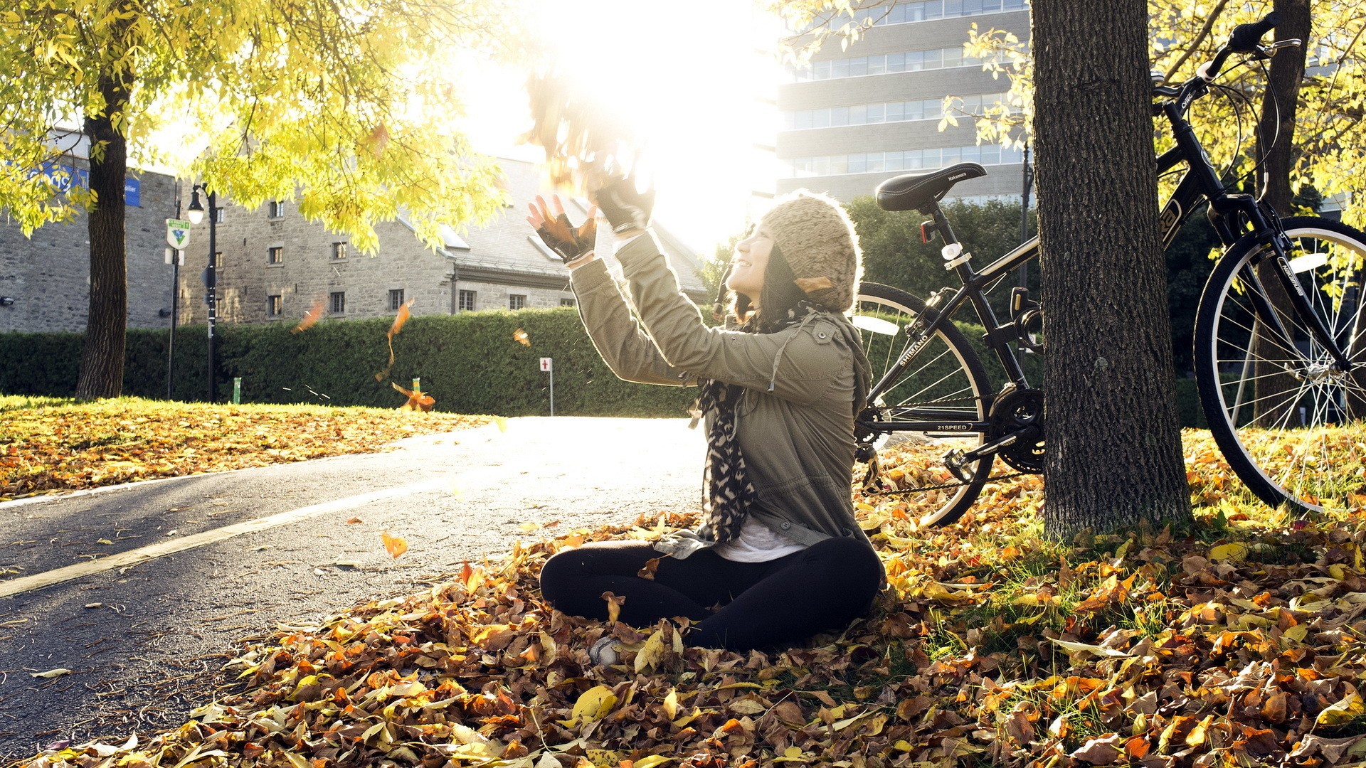 People 1920x1080 fall trees bicycle road sitting sunlight women outdoors hat women with bicycles fallen leaves arms up looking up wool cap women