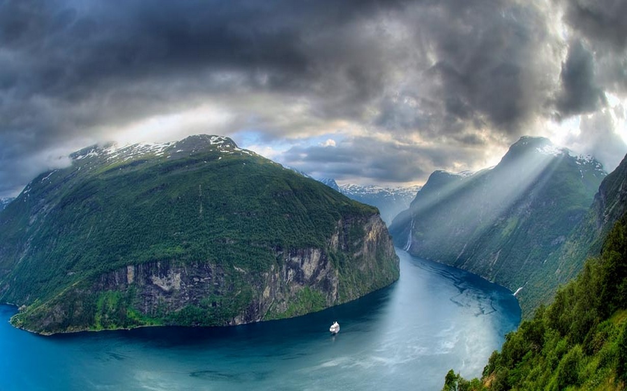 General 1230x768 nature landscape Geiranger fjord Norway sun rays mountains clouds cruise ship cliff snowy peak Geirangerfjord