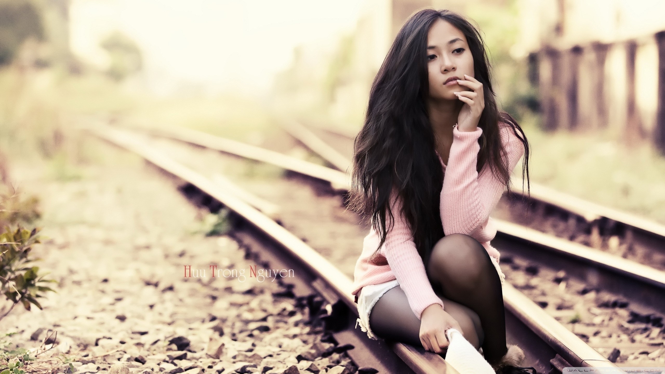 People 2560x1440 railway Asian women women outdoors Huu Trong Nguyen outdoors looking into the distance sitting dark hair legs together sweater jean shorts