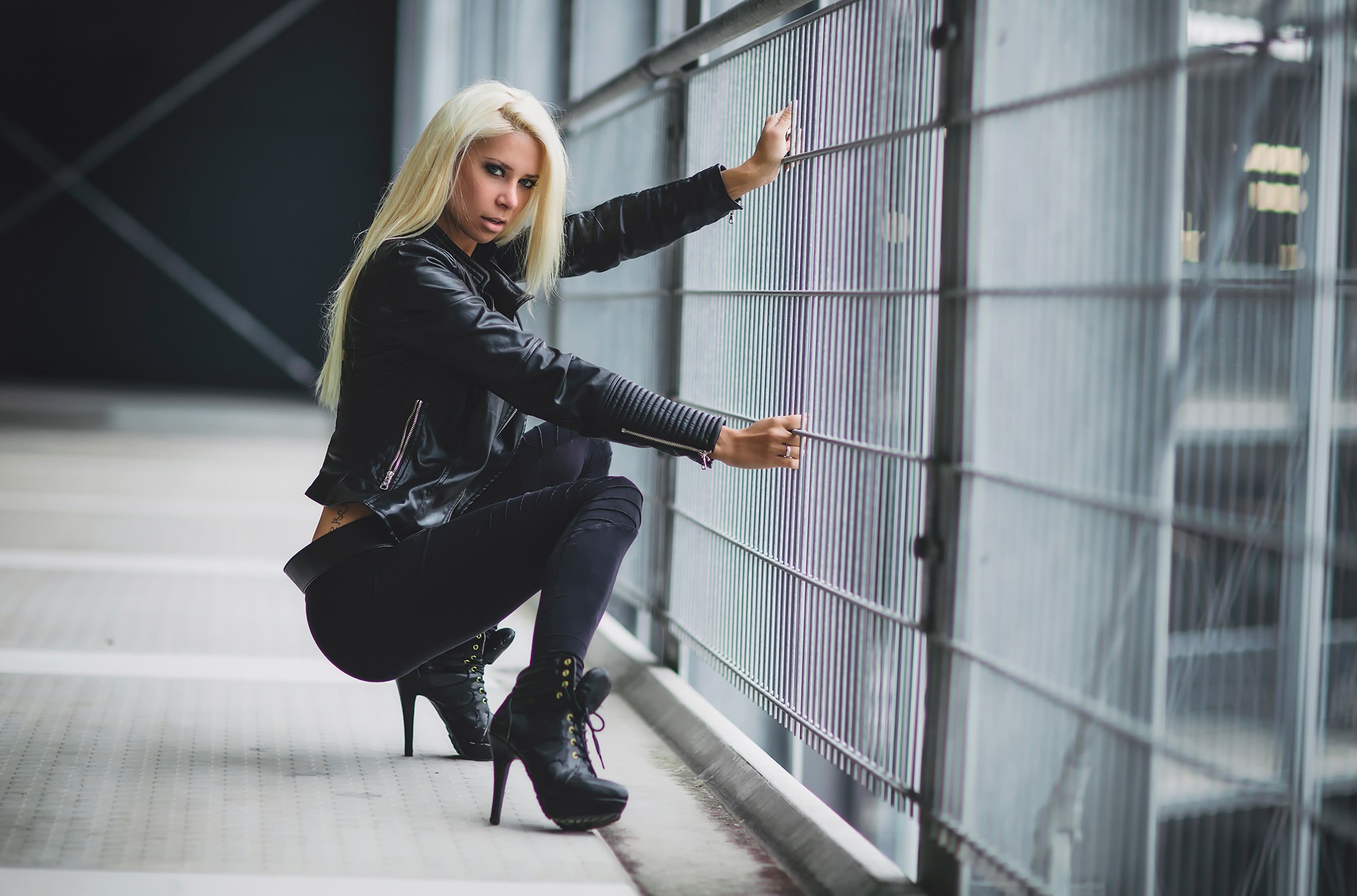 People 2048x1352 Angela Kutscher women blonde heels makeup dyed hair leather jacket fence squatting