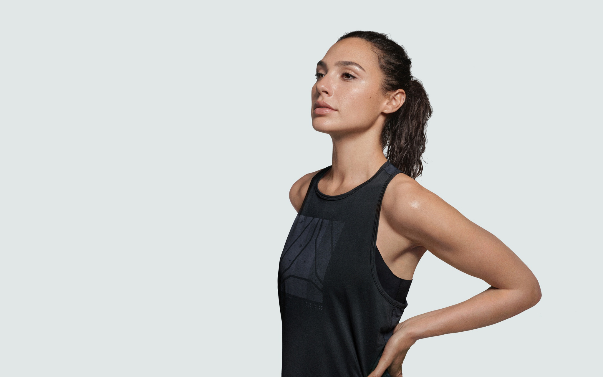 People 2048x1280 Gal Gadot ponytail black clothing brunette black t-shirt tank top hand on belly celebrity women sportswear black top looking into the distance actress
