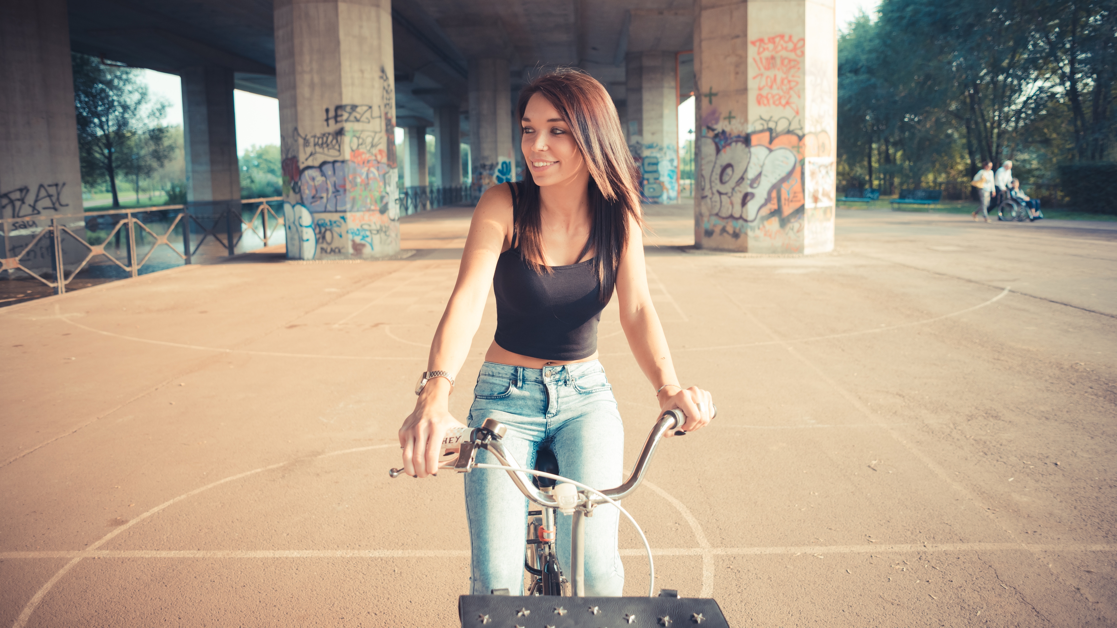 People 3840x2160 women bicycle jeans bare midriff brunette long hair graffiti smiling 4K women outdoors urban vehicle looking away outdoors women with bicycles wristwatch dyed hair black top straight hair frontal view