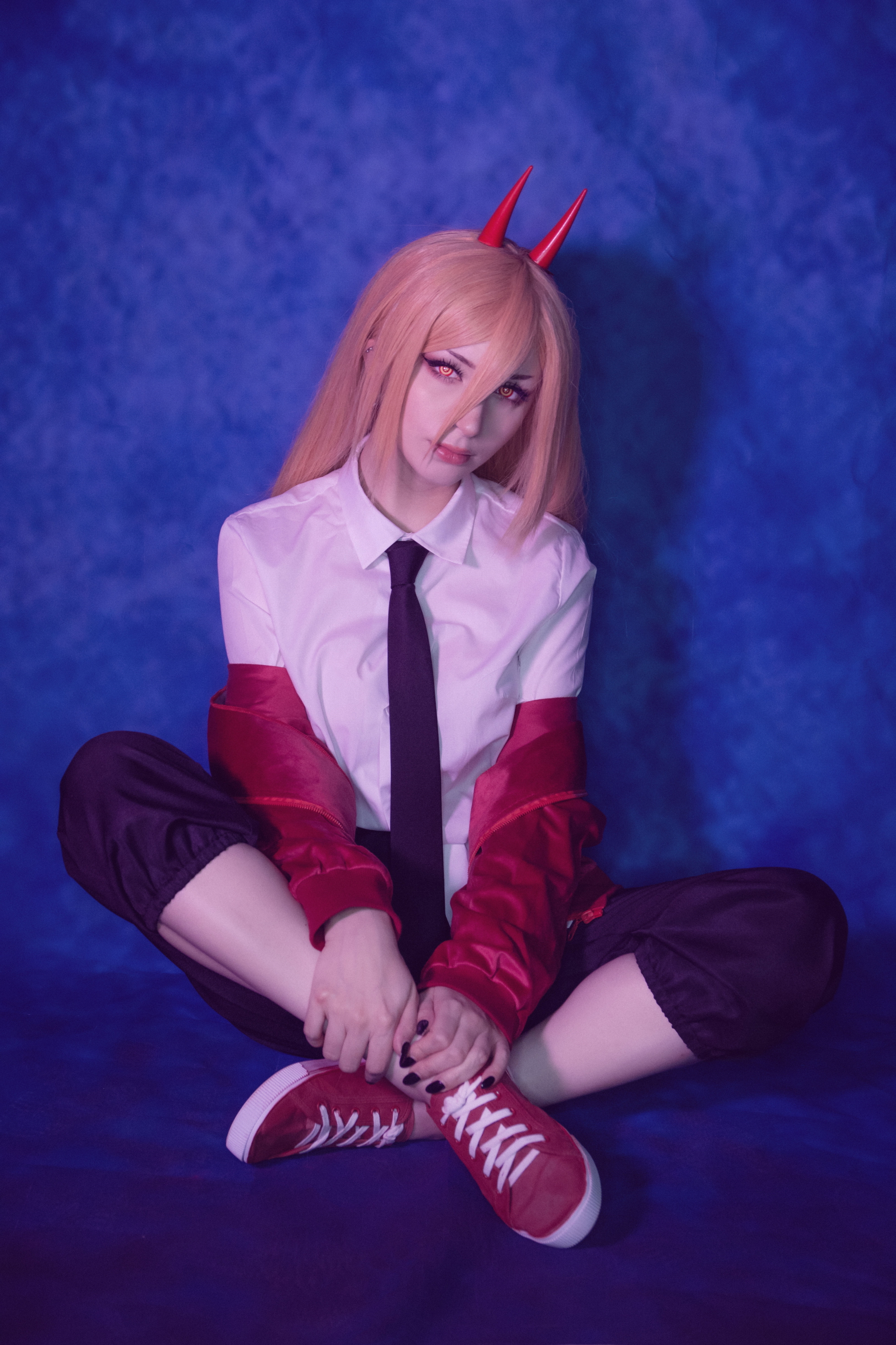 People 1813x2720 Shiro Kitsune (model) women cosplay Power (Chainsaw Man) Chainsaw Man studio shirt tie sneakers indoors women indoors contact lenses red shoes blue background looking at viewer Asian legs crossed long hair hair in face horns model
