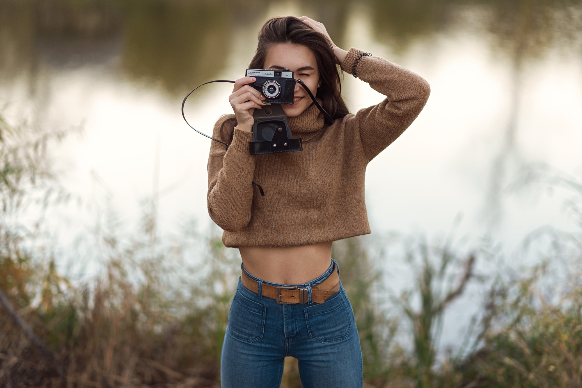 People 2000x1335 women outdoors brunette camera jeans women depth of field hands on head high waisted belly smiling bokeh sweater turtlenecks frontal view brown sweater blue pants covering face portrait young women blue  jeans tight pants brown belt leather belt
