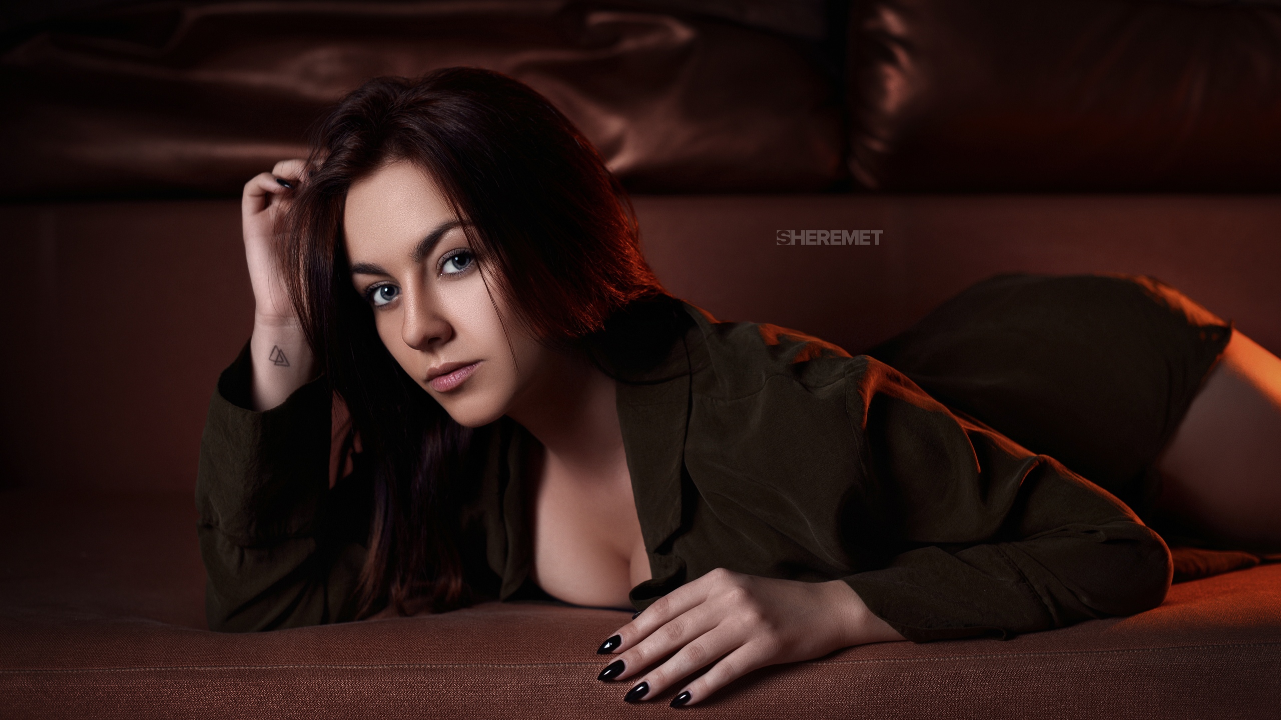 People 2560x1440 women brunette long hair looking at viewer touching hair gray eyes black nails painted nails portrait lying on front cleavage shirt couch depth of field indoors women indoors Ivan Sheremet