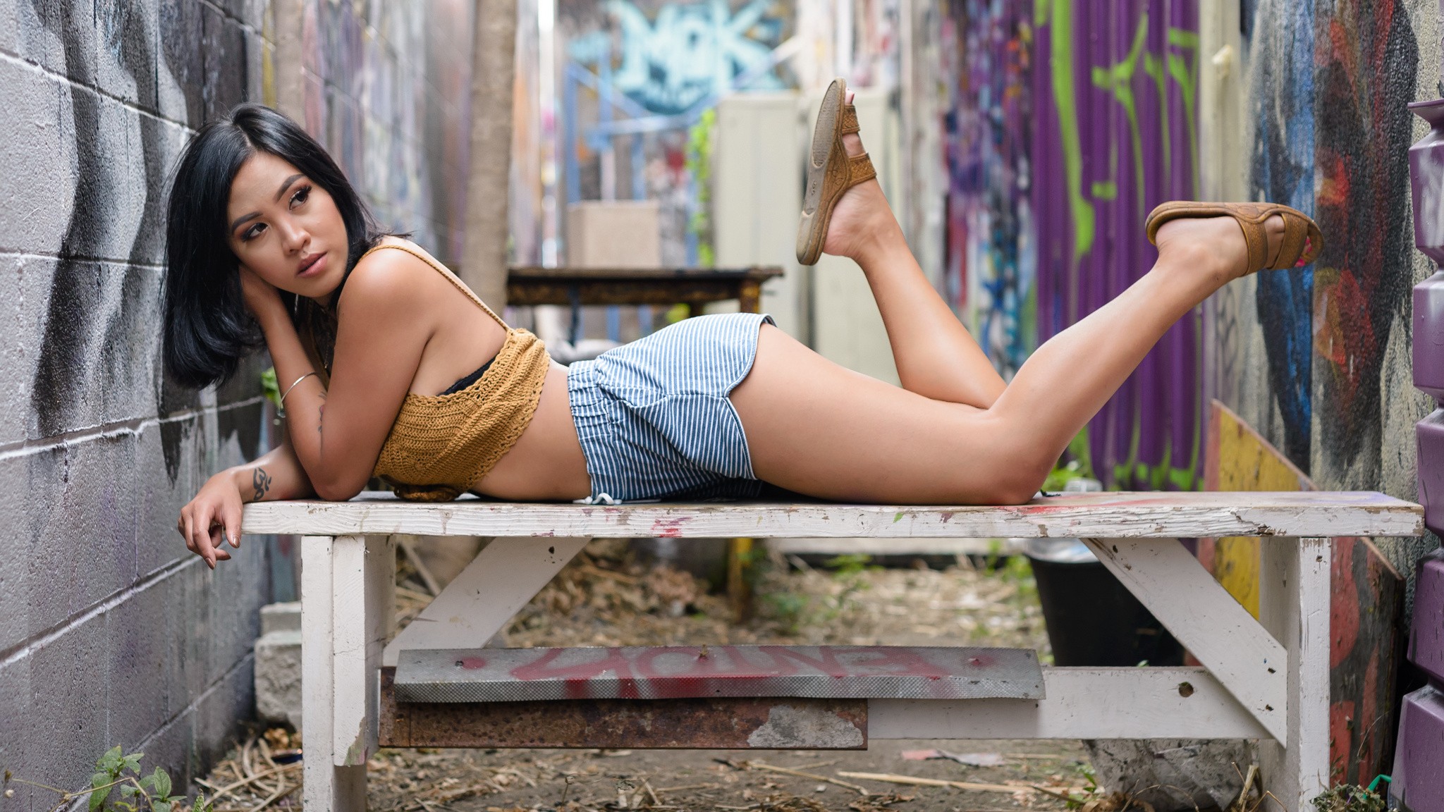 People 2048x1152 Gizel Ramos shorts ass looking away legs up sandals tattoo lying on front looking up black hair inked girls women outdoors urban painted toenails women model