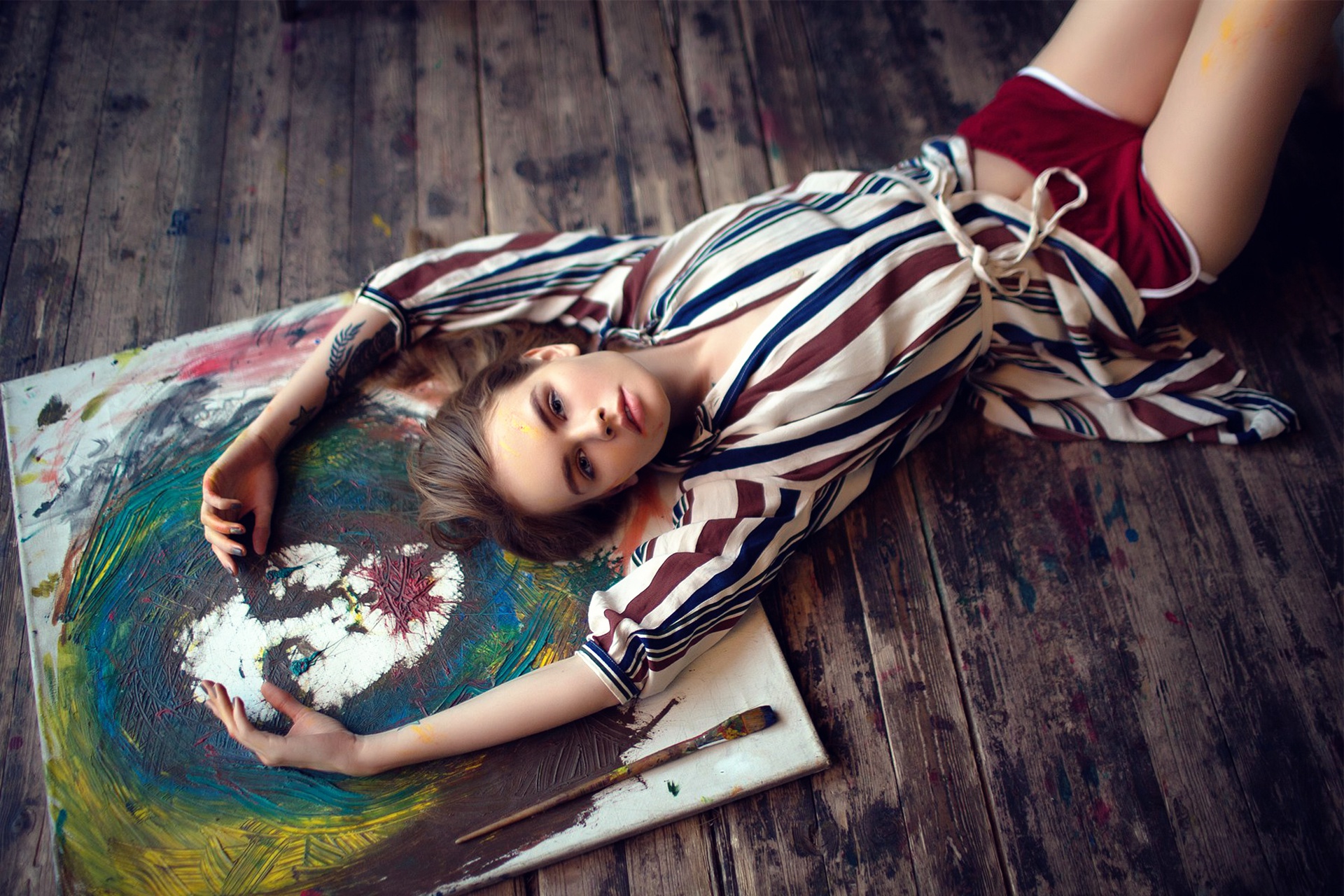 People 1920x1280 Anastasia Scheglova women blonde model lying down tattoo shorts painting on the floor wooden surface brush paint splatter face looking at viewer lying on back
