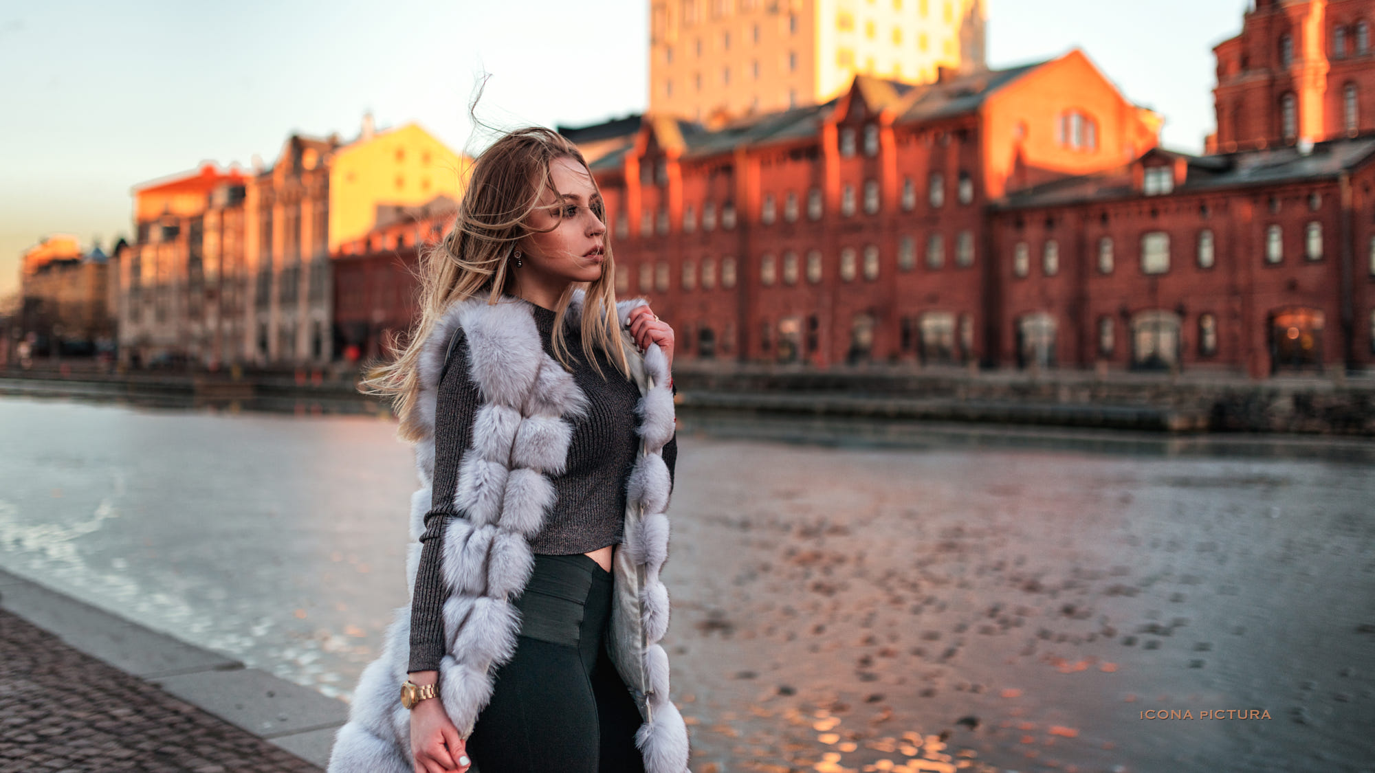 People 2000x1125 Icona Pictura women 500px photography grey sweater riverside windy fur women outdoors side view public blonde looking into the distance watch one arm up black pants hair blowing in the wind model young women
