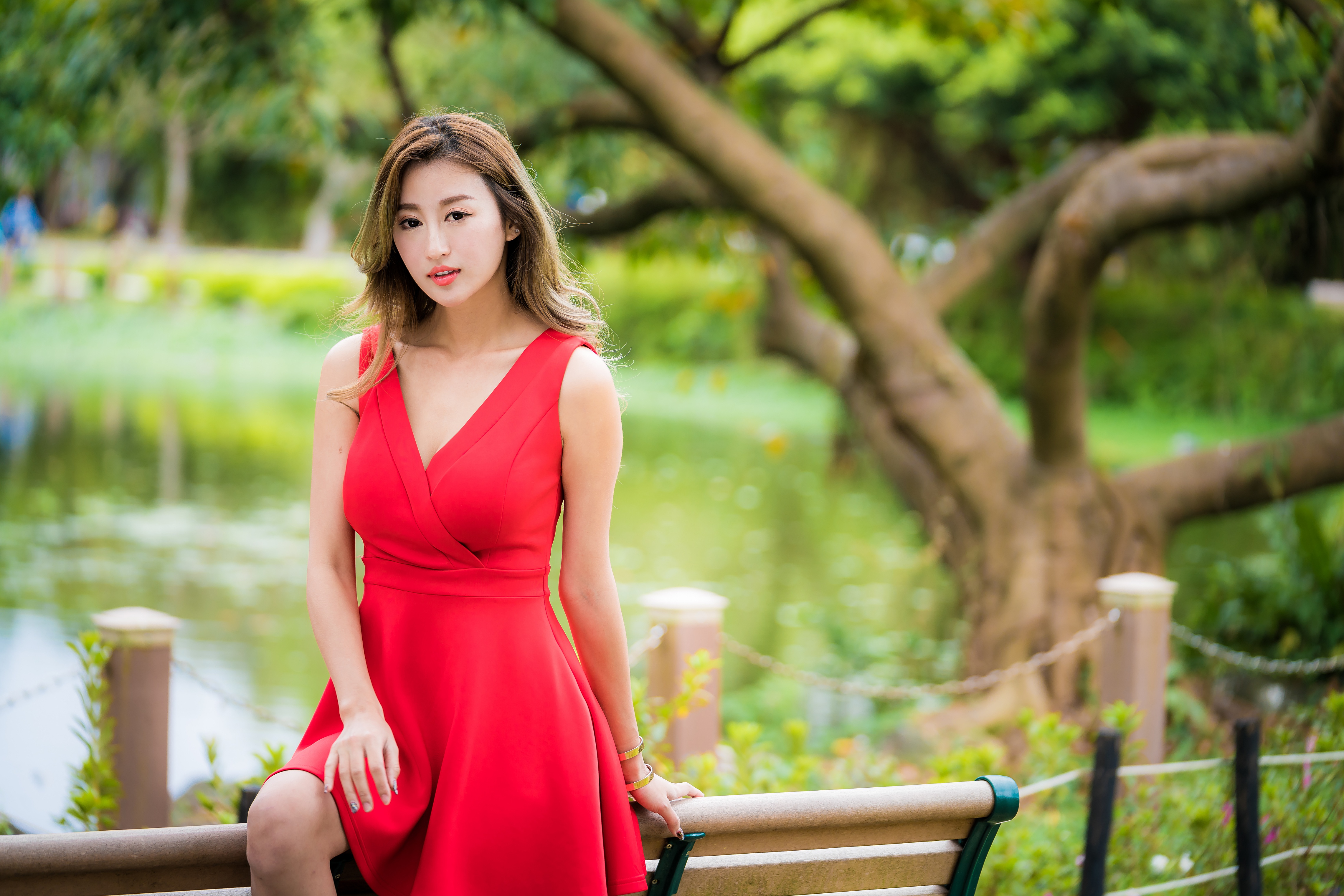 People 4562x3043 Asian women model red dress depth of field plants trees sitting bench pond bracelets brunette long hair chains women outdoors looking at viewer
