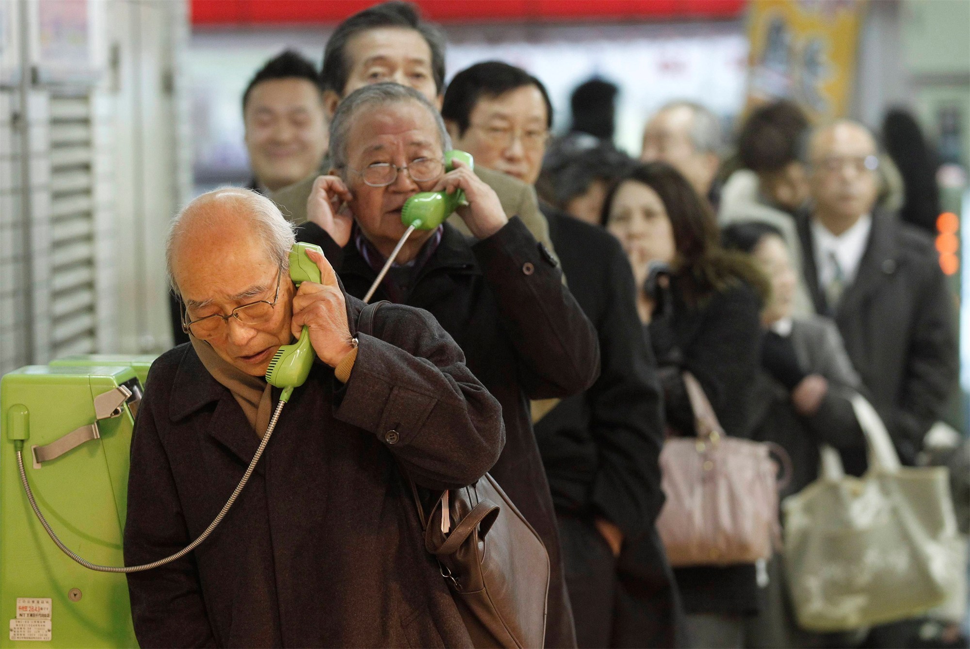 People 2000x1337 Japan crowds queue depth of field phone men women purse men with glasses standing old people japanese man Japanese bald