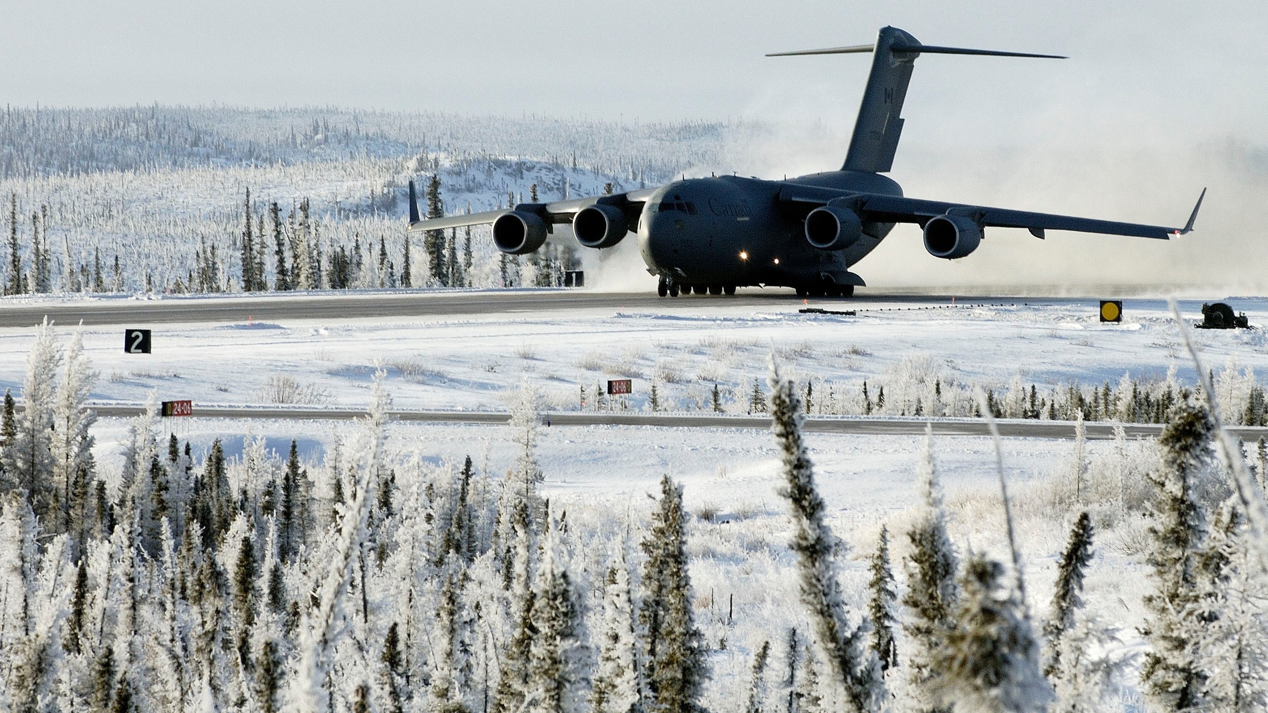 General 2560x1440 military aircraft military aircraft airplane Boeing C-17 Globemaster III Royal Canadian Air Force snow winter military vehicle vehicle cold outdoors Boeing American aircraft Canada frontal view snow covered trees smoke