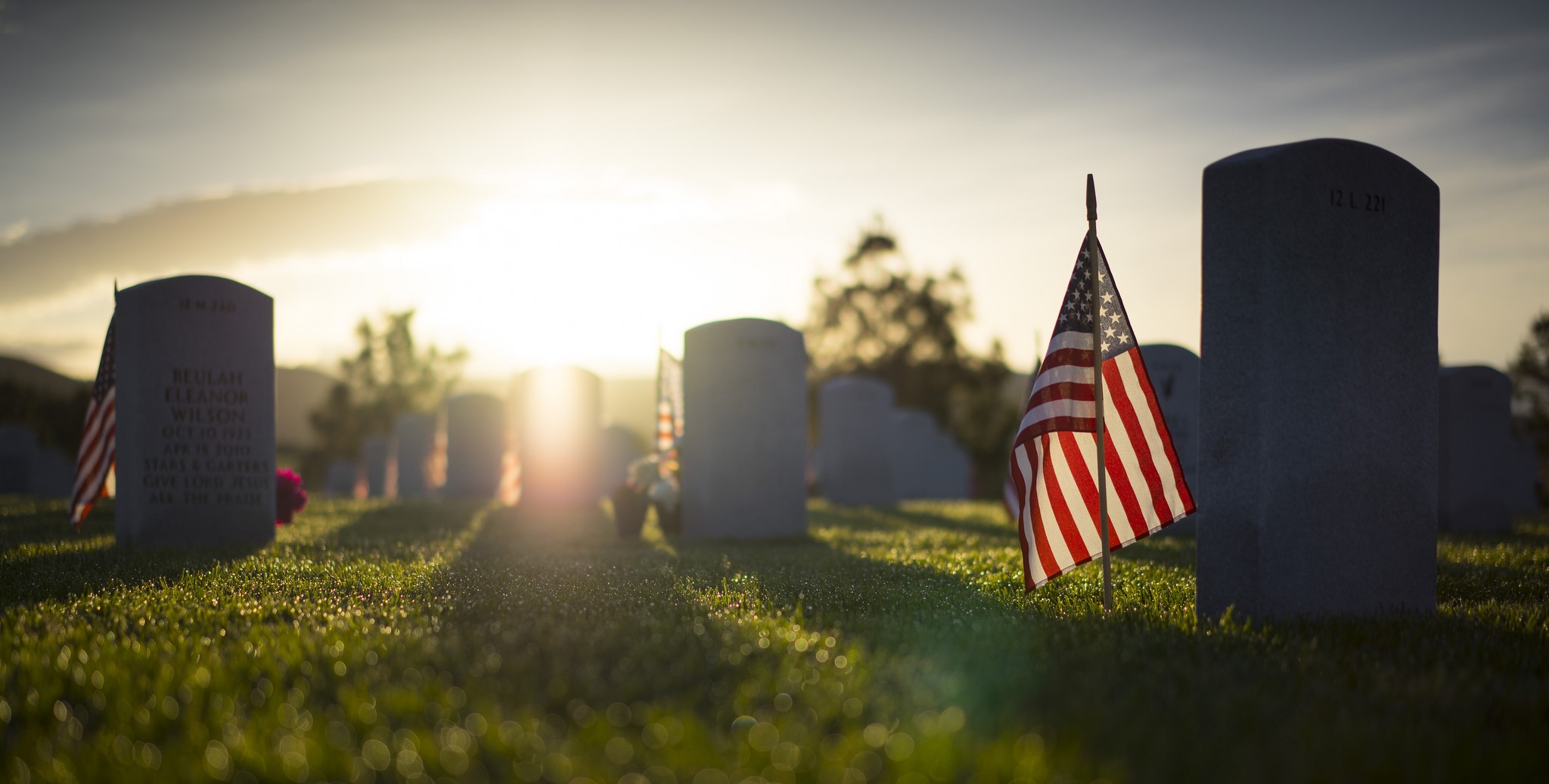 General 2048x1037 USA military memorial patriotic American flag tombstones graveyards sunlight