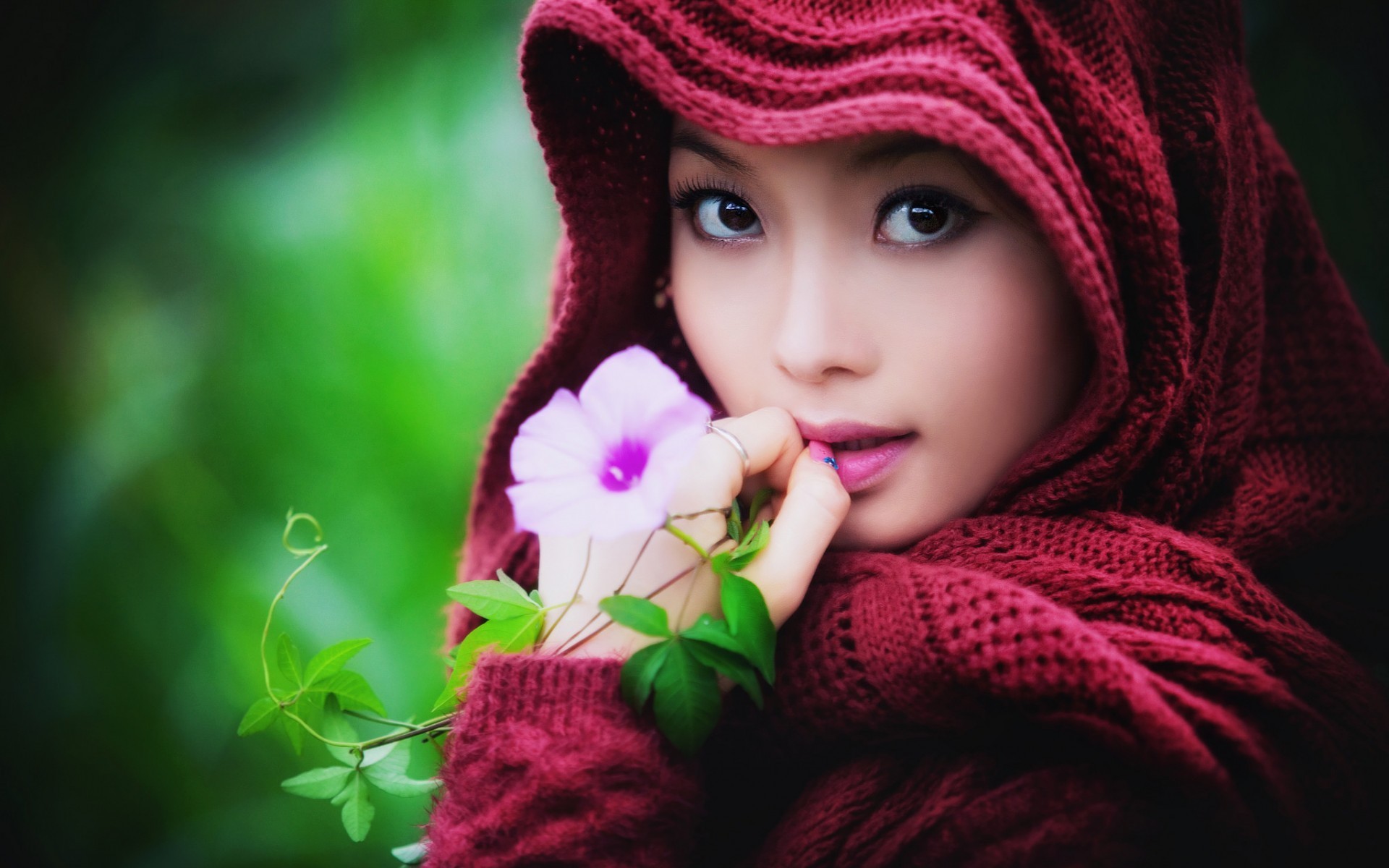 People 1920x1200 women model women outdoors Asian looking at viewer brown eyes flowers hoods sweater leaves face biting finger portrait rings depth of field scarf closeup pink lipstick green background