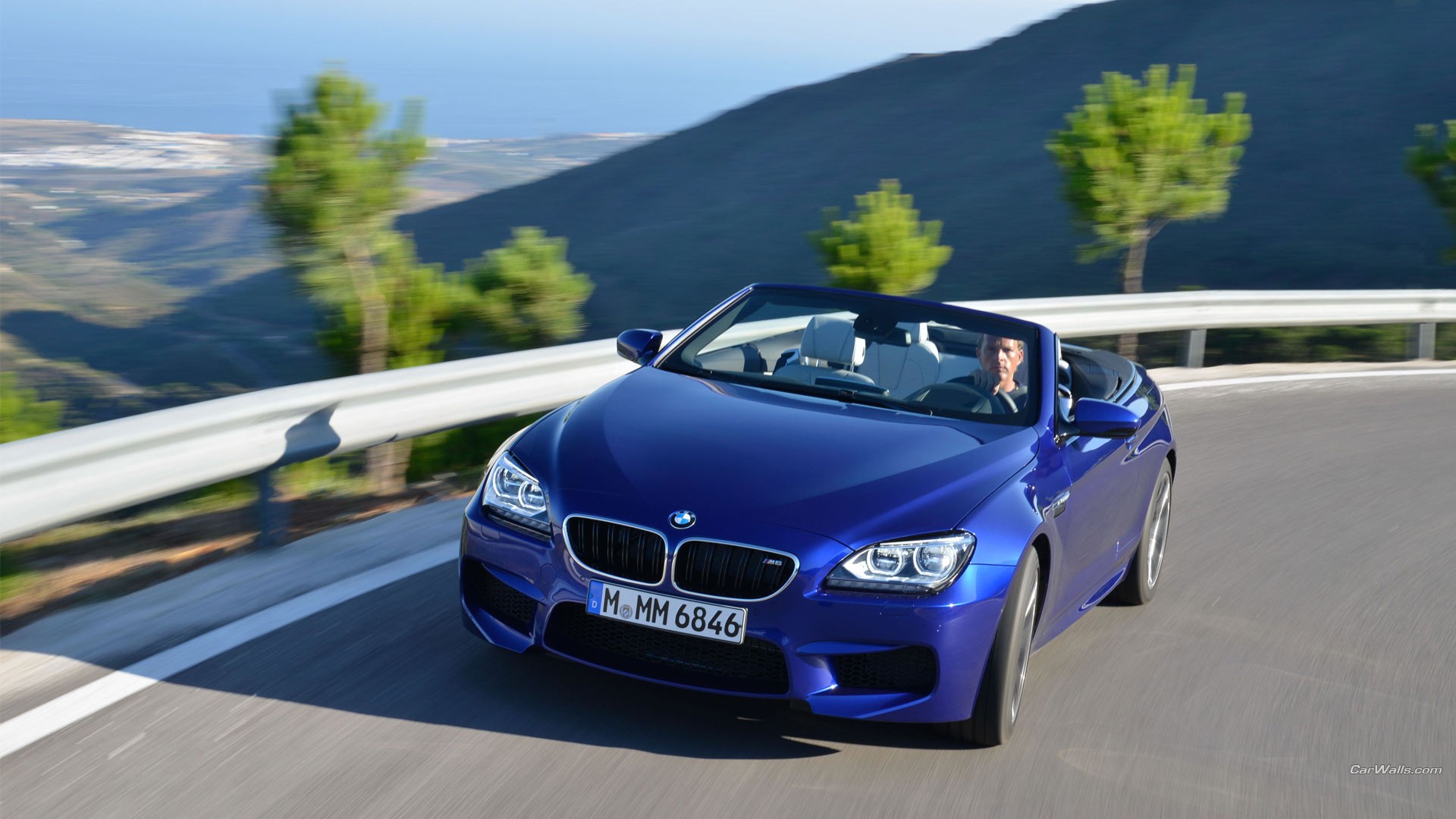 General 1920x1080 convertible blue cars Roadster German cars BMW M6 frontal view motion blur watermarked road men driving blurred blurry background sunlight looking at viewer closed mouth licence plates trees vehicle BMW