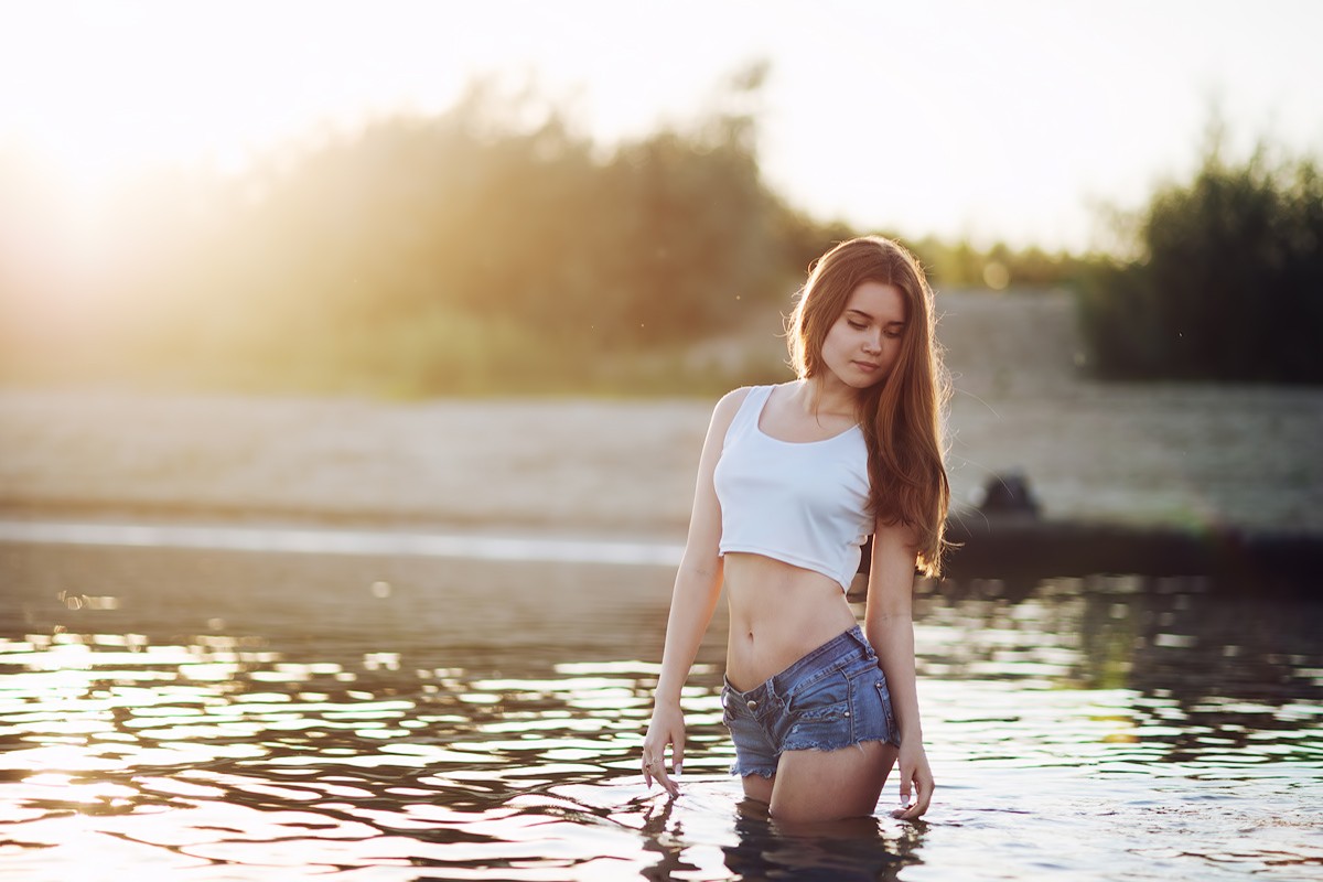 People 1200x800 Polina Sterzhnykh women T-shirt jean shorts sunset river skinny in water short shorts slim body brunette white tops long hair looking away short tops crop top blue shorts standing in water model tank top bare midriff Daisy Dukes women outdoors belly