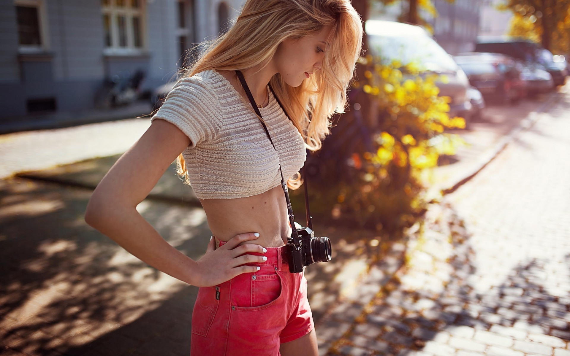 People 1920x1200 blonde camera women skinny Andre Josselin urban women outdoors model boobs outdoors belly long hair standing short tops shorts hands on hips see-through clothing depth of field