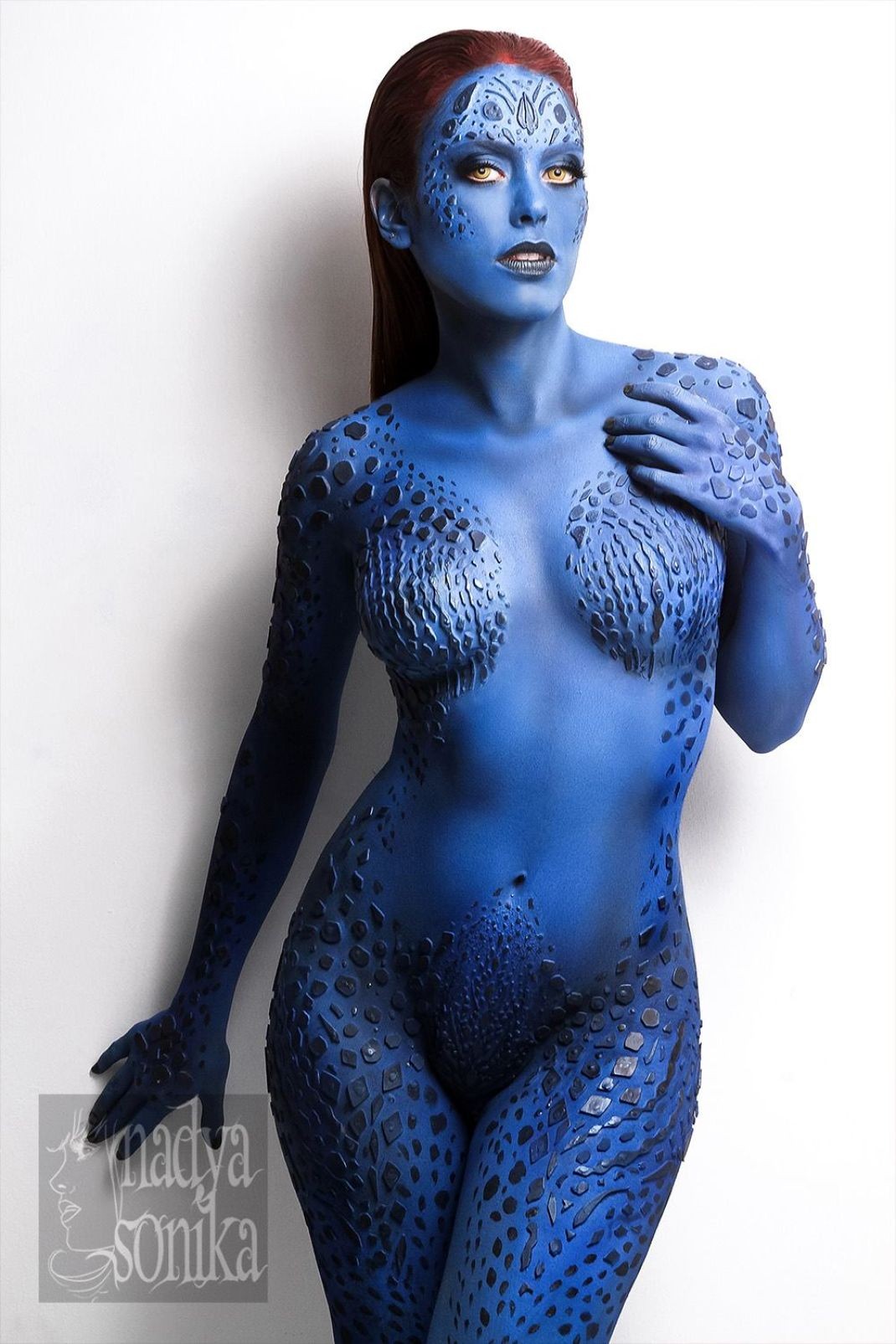 People 1070x1605 Mystique cosplay X-Men body paint blue redhead women model blue skin looking at viewer yellow eyes white background simple background studio indoors women indoors boobs belly standing