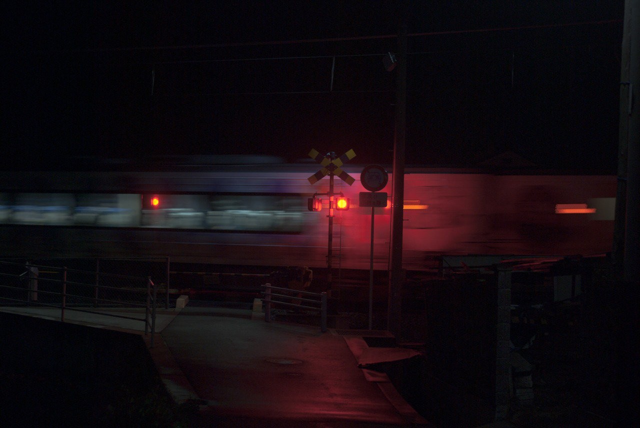 General 1280x857 train railway crossing vehicle night dark motion blur red light