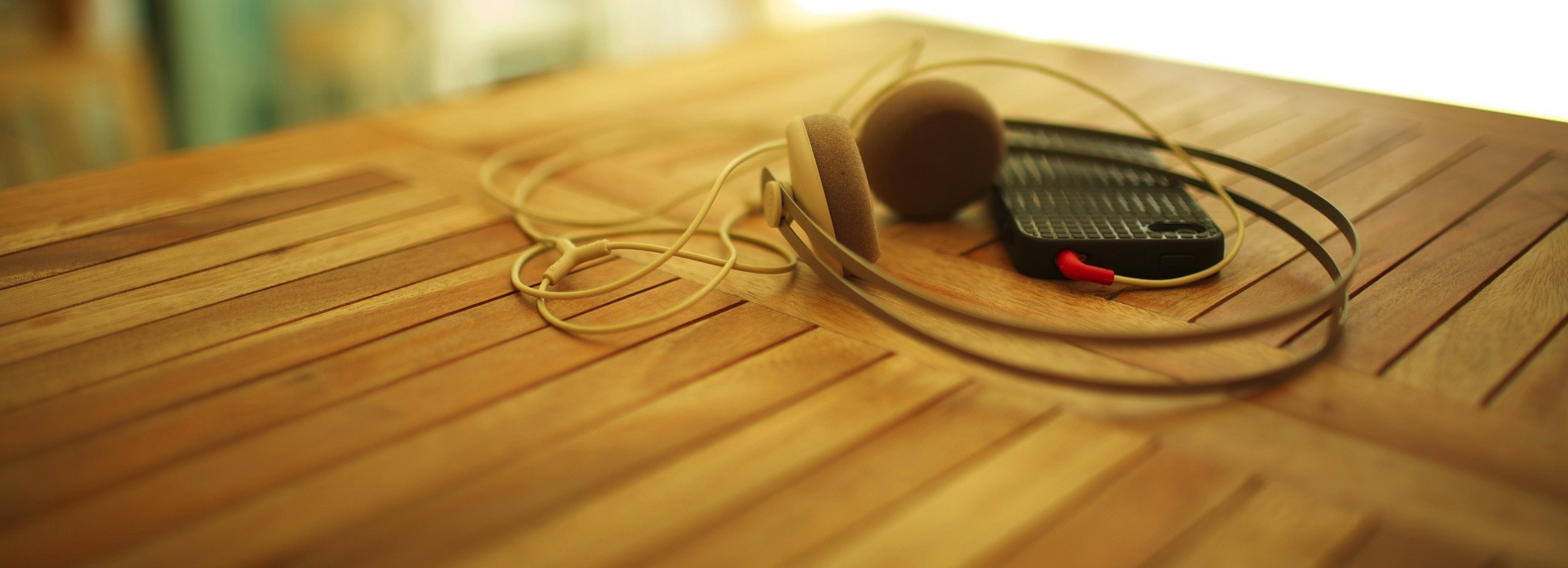 General 2560x928 wooden surface technology blurred macro headphones