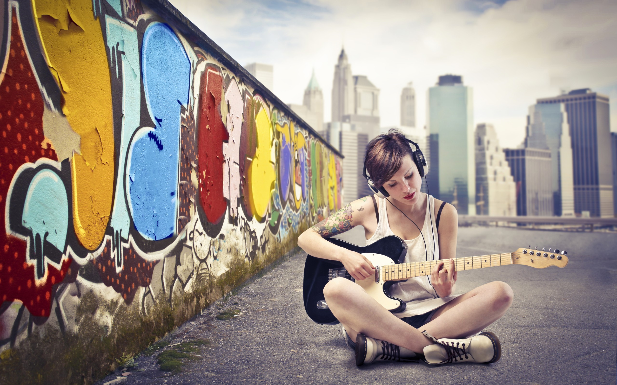 People 2560x1600 women guitar cityscape graffiti brunette headphones musical instrument sitting wall urban inked girls legs legs crossed