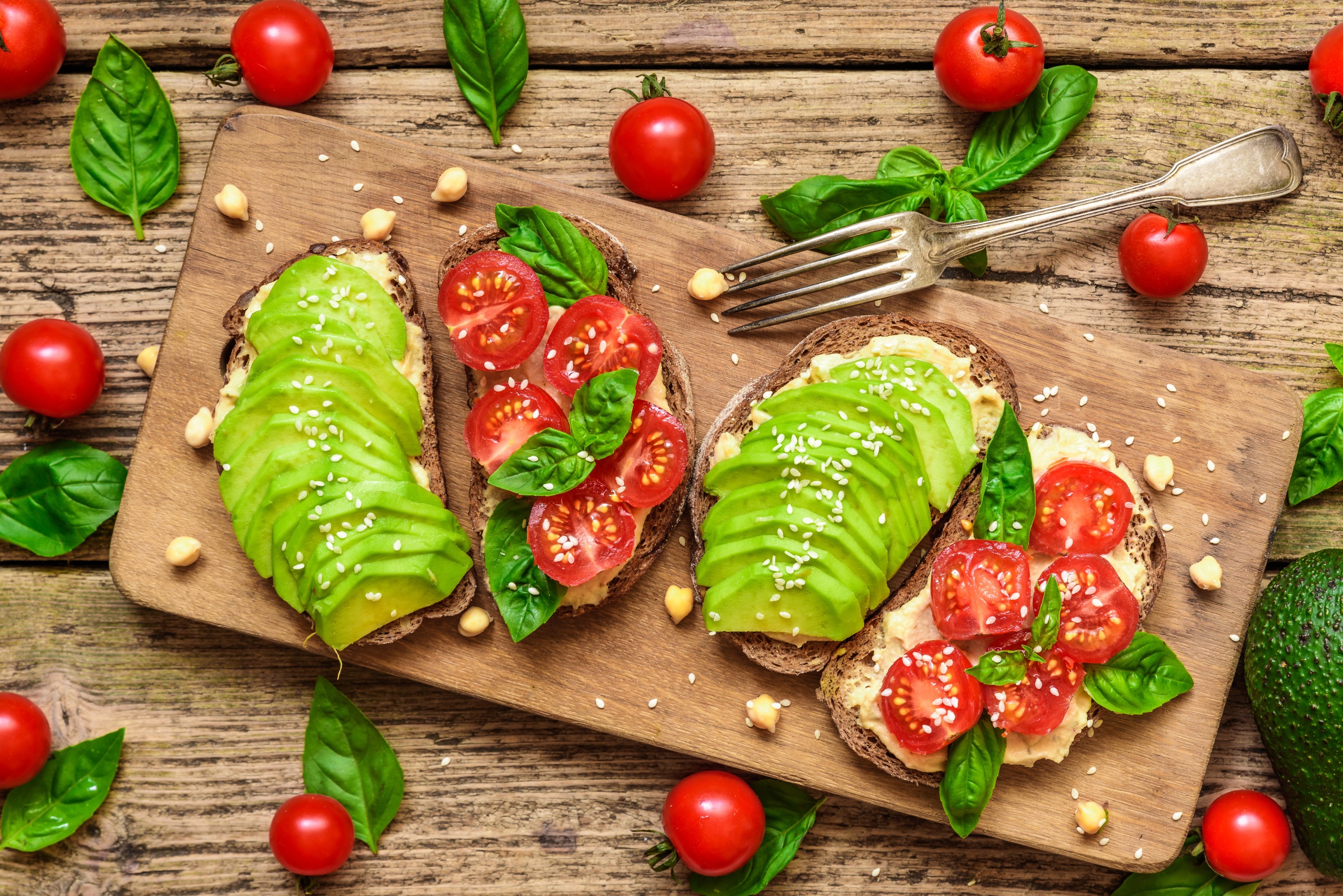 General 2560x1708 food bread fork tomatoes wooden surface cutting board toasts avocados basil closeup