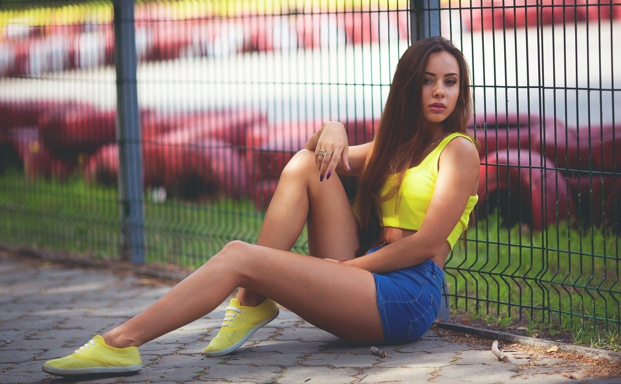People 2048x1265 women sitting jean shorts sneakers looking at viewer brunette women outdoors urban painted nails Yellow Shoes fence model long hair