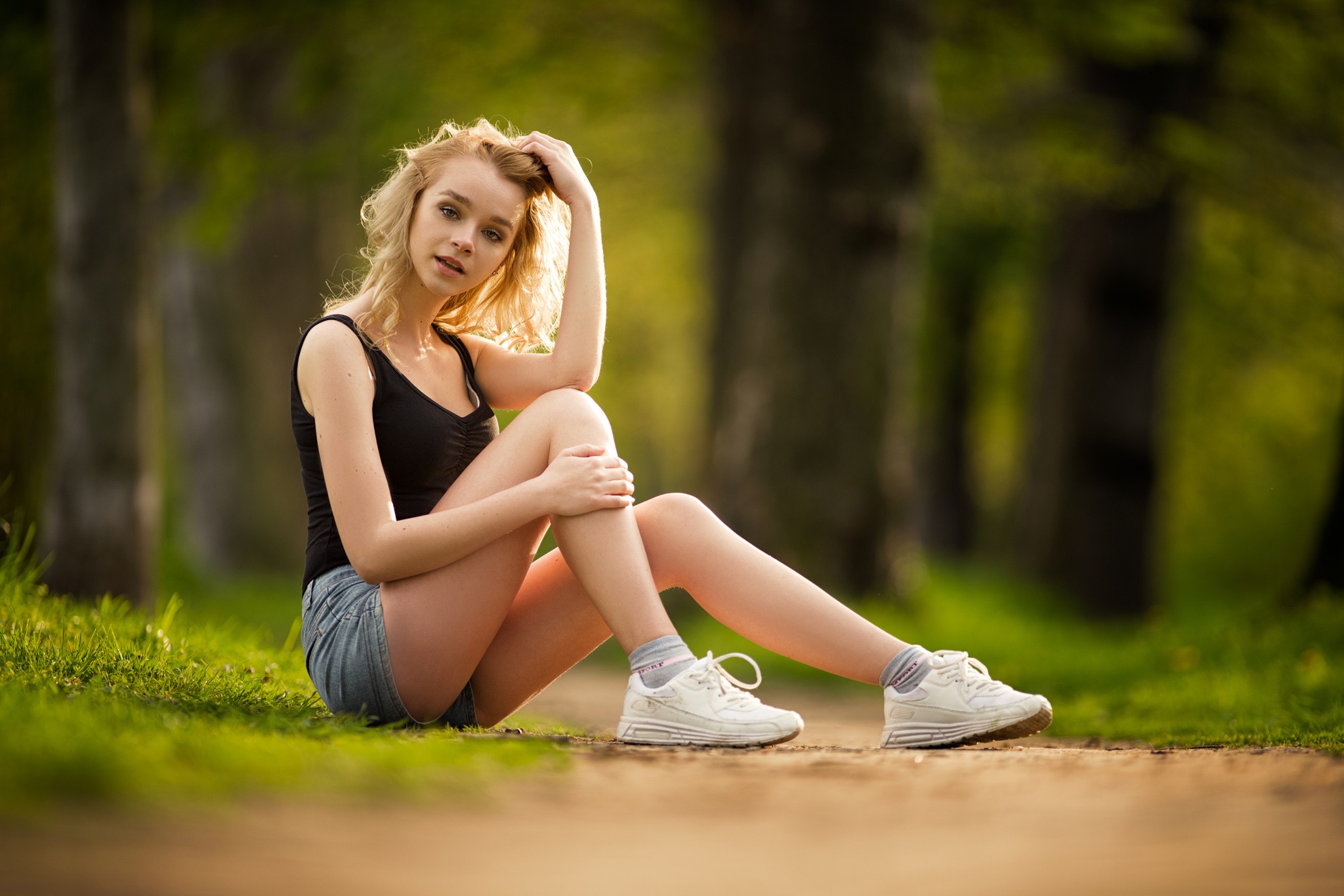 People 2048x1366 women blonde hand(s) on head jean shorts sneakers women outdoors socks sitting thighs legs white shoes looking at viewer green background model