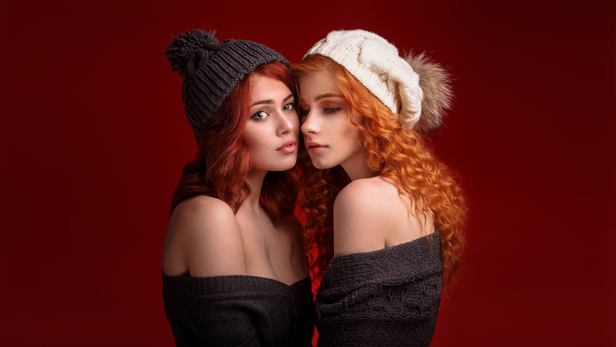 People 2133x1200 Anastasia Zhilina two women looking at viewer redhead curly hair long hair side view woolly hat knit fabric knit hat sweater bare shoulders portrait women red background simple background Alexandr Chuprina wool cap cleavage white cap grey caps Caucasian face to face