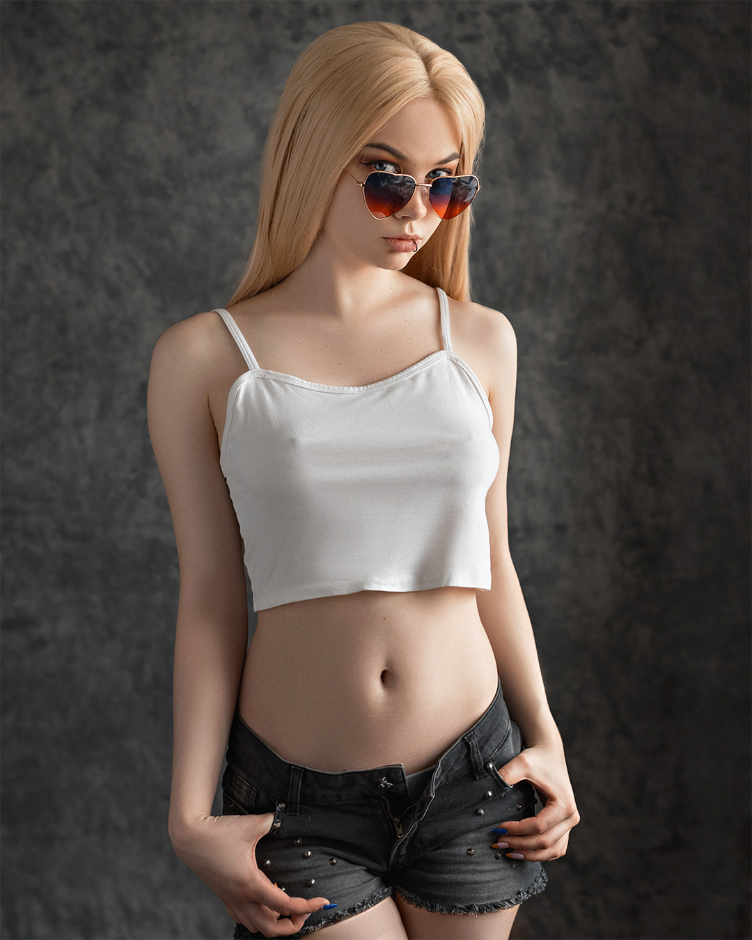 People 1080x1350 women blonde looking at viewer piercing tank top white clothing see-through clothing nipples through clothing nipple bulge pierced nipples belly shorts jeans hands in pockets
