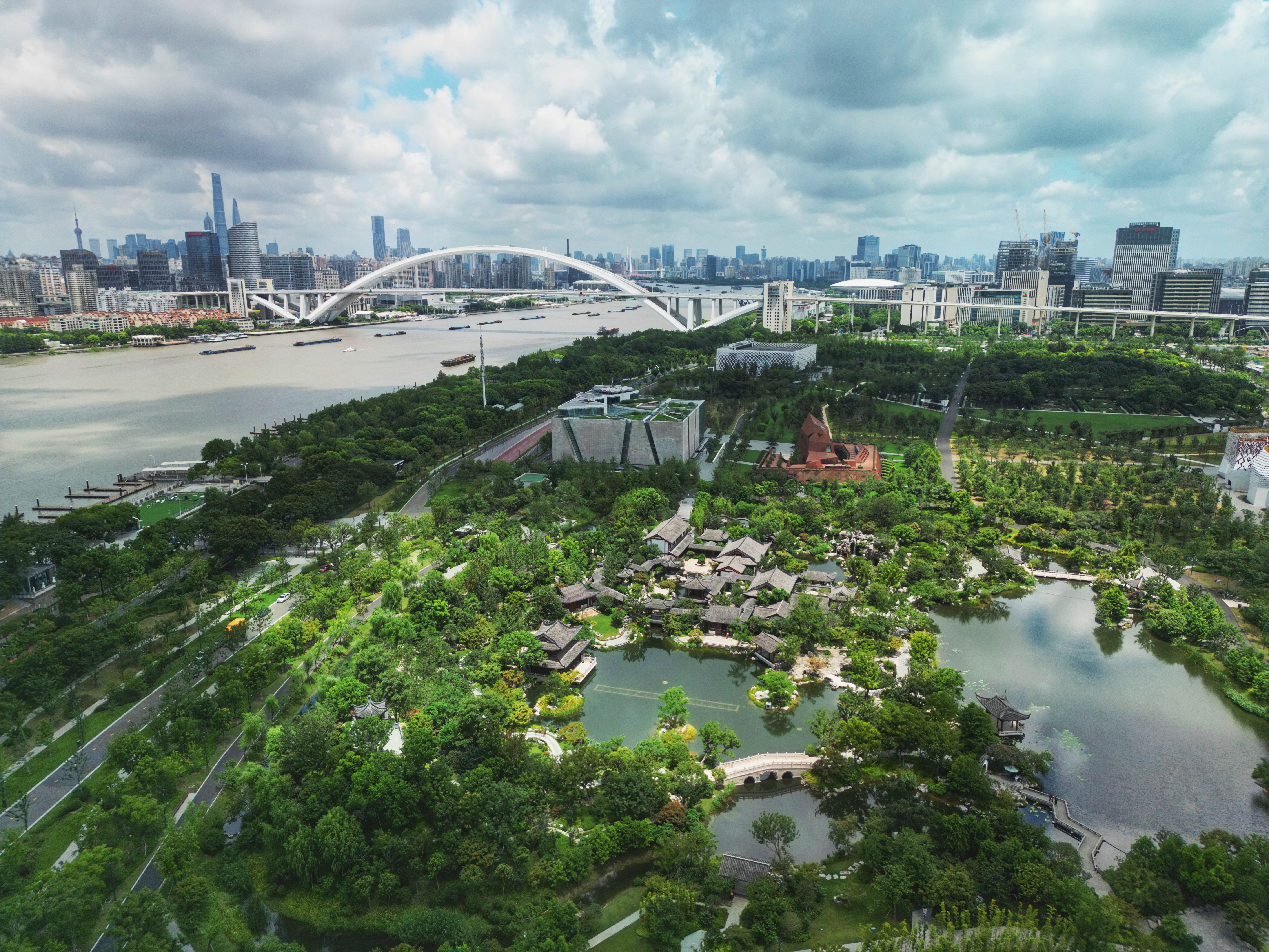 General 5773x4330 landscape city drone photo Shanghai water trees bridge sky clouds building