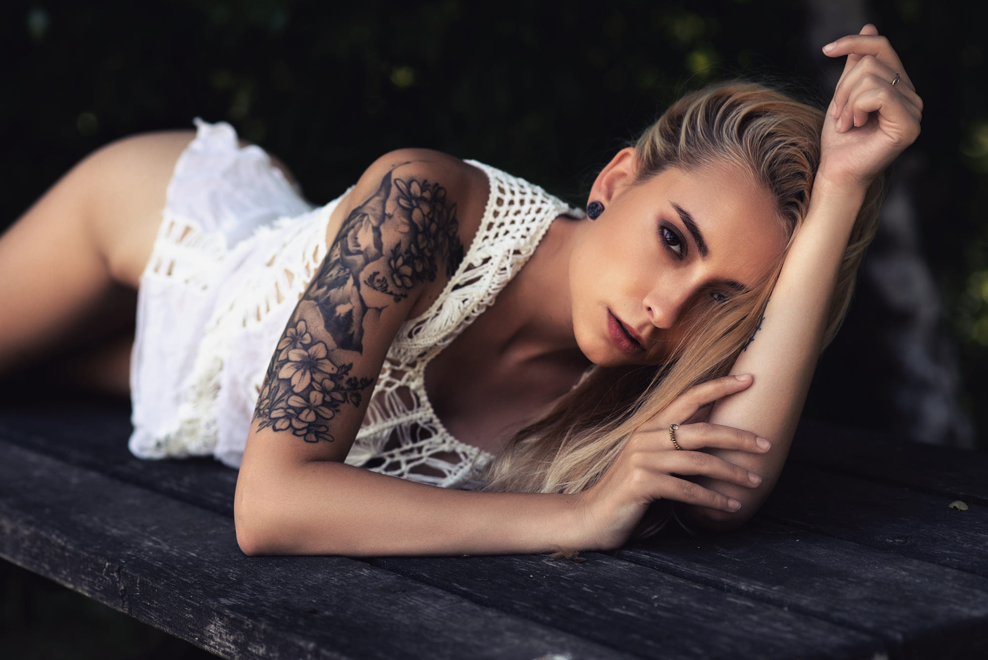 People 2000x1335 women blonde brown eyes white shirt lying down looking at viewer tattoo bottomless rings open mouth depth of field model photography