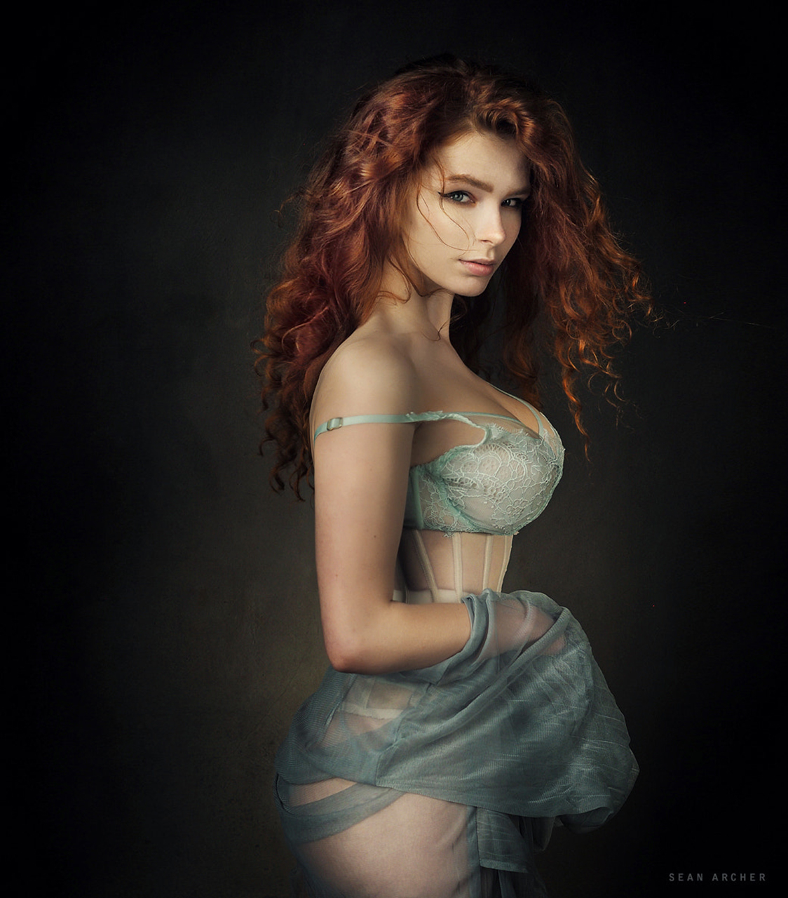 People 1124x1280 Sean Archer women Carina Vulpes redhead long hair curly hair makeup looking at viewer lingerie corset skirt holding clothes see-through clothing white clothing simple background portrait display watermarked model cleavage