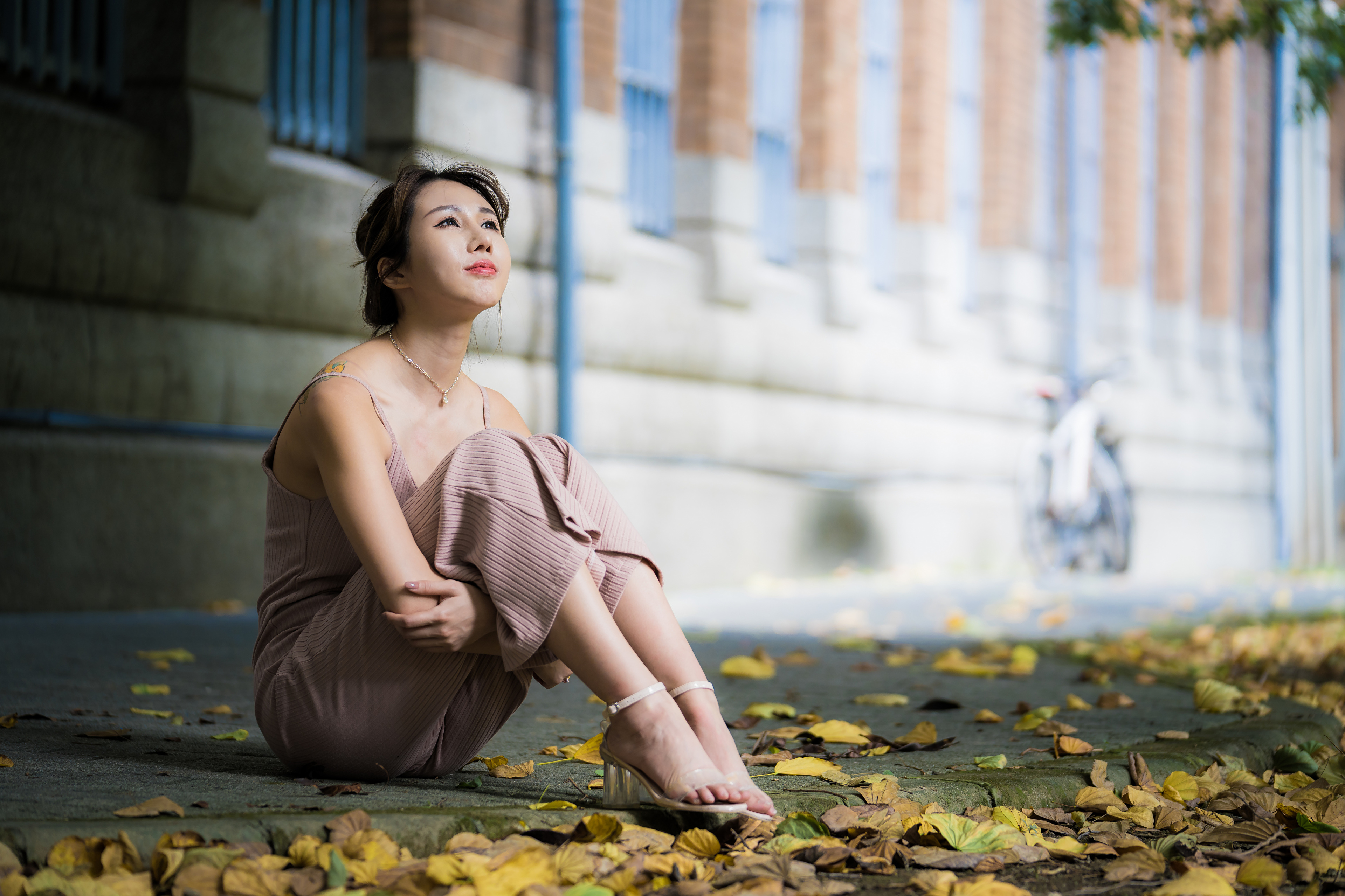 People 3840x2559 Asian model women depth of field long hair dark hair women outdoors sitting barefoot sandal leaves looking up building pink dress necklace tattoo hair knot