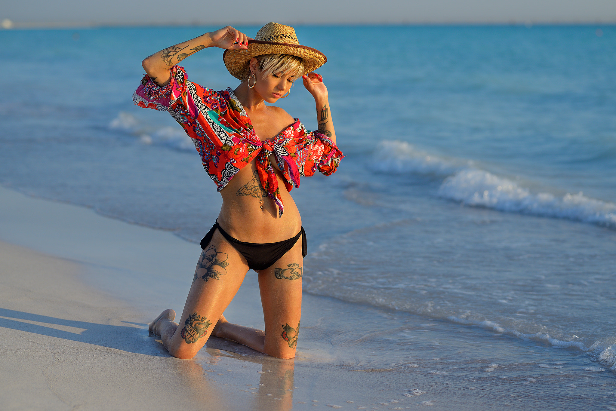 People 2048x1367 Giovanni Zacche women kneeling sand sea tattoo belly women outdoors closed eyes red nails pierced navel blonde short hair hat model Giorgia Soleri