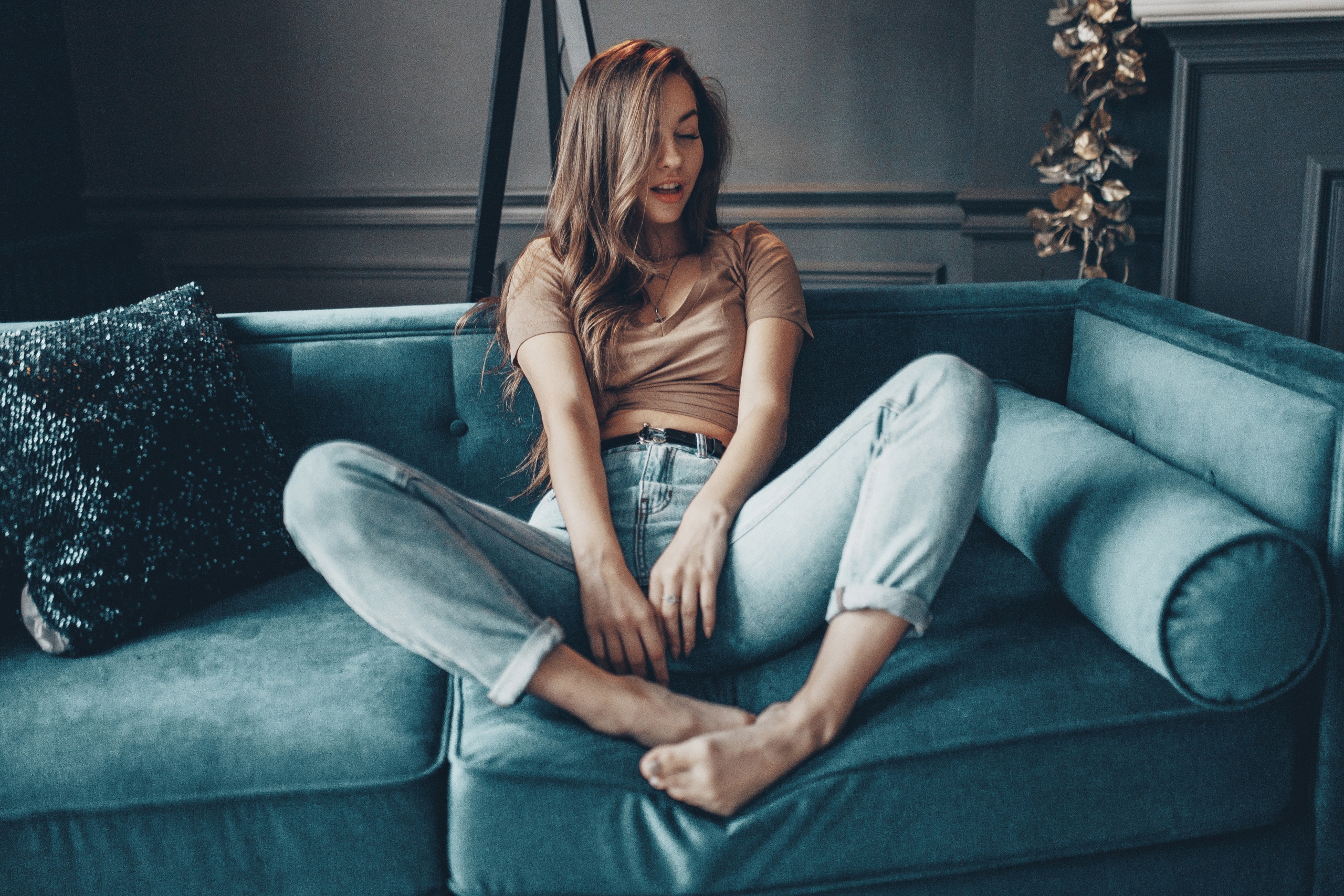 People 2560x1707 women model brunette long hair closed eyes necklace T-shirt jeans sitting barefoot bokeh couch frontal view indoors women indoors cushions toes pointed toes feet pressed open mouth Olga Laferova