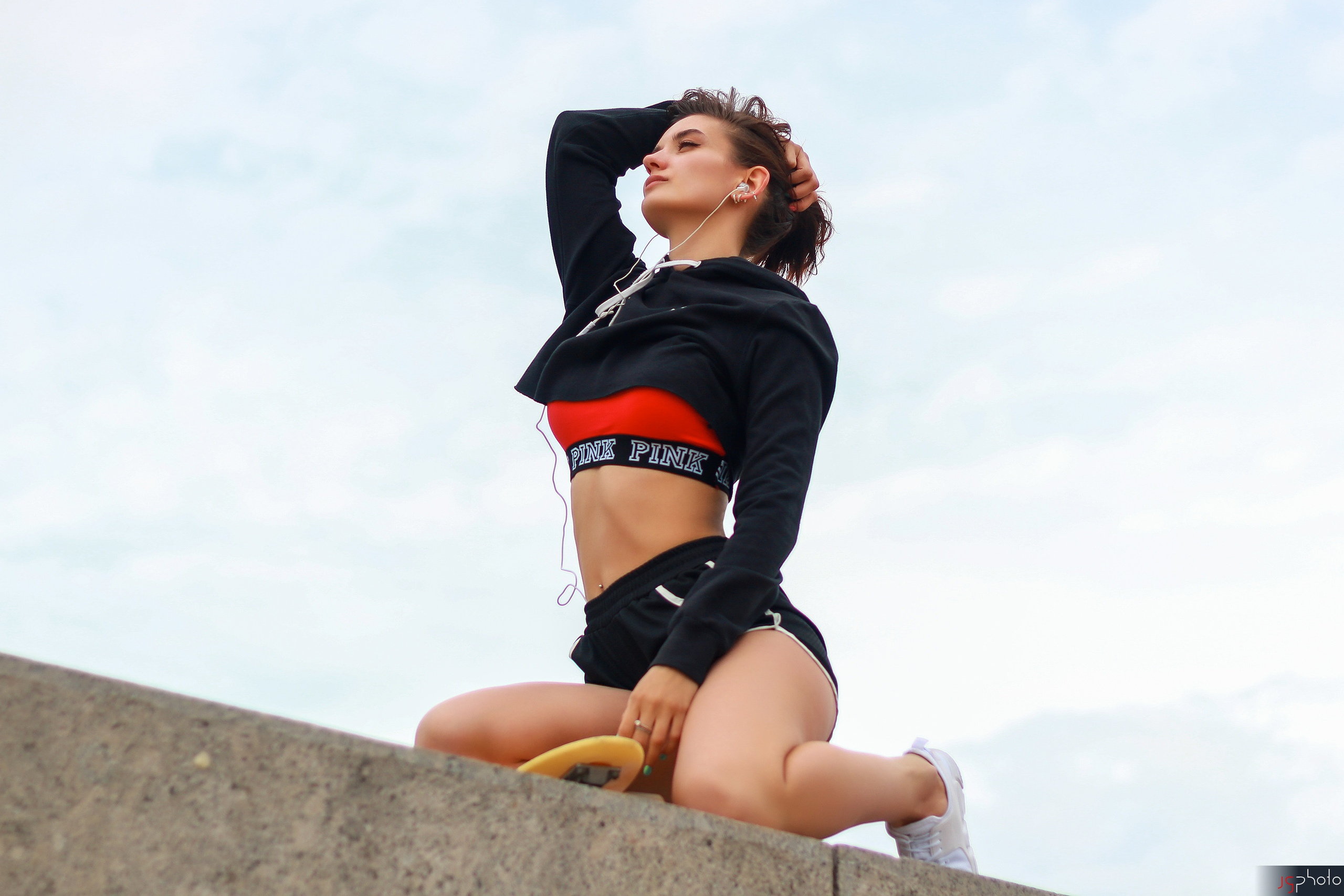 People 2560x1707 women model brunette ponytail sweatshirts belly pierced navel short shorts kneeling holding hair looking into the distance sky sneakers headphones women outdoors low-angle