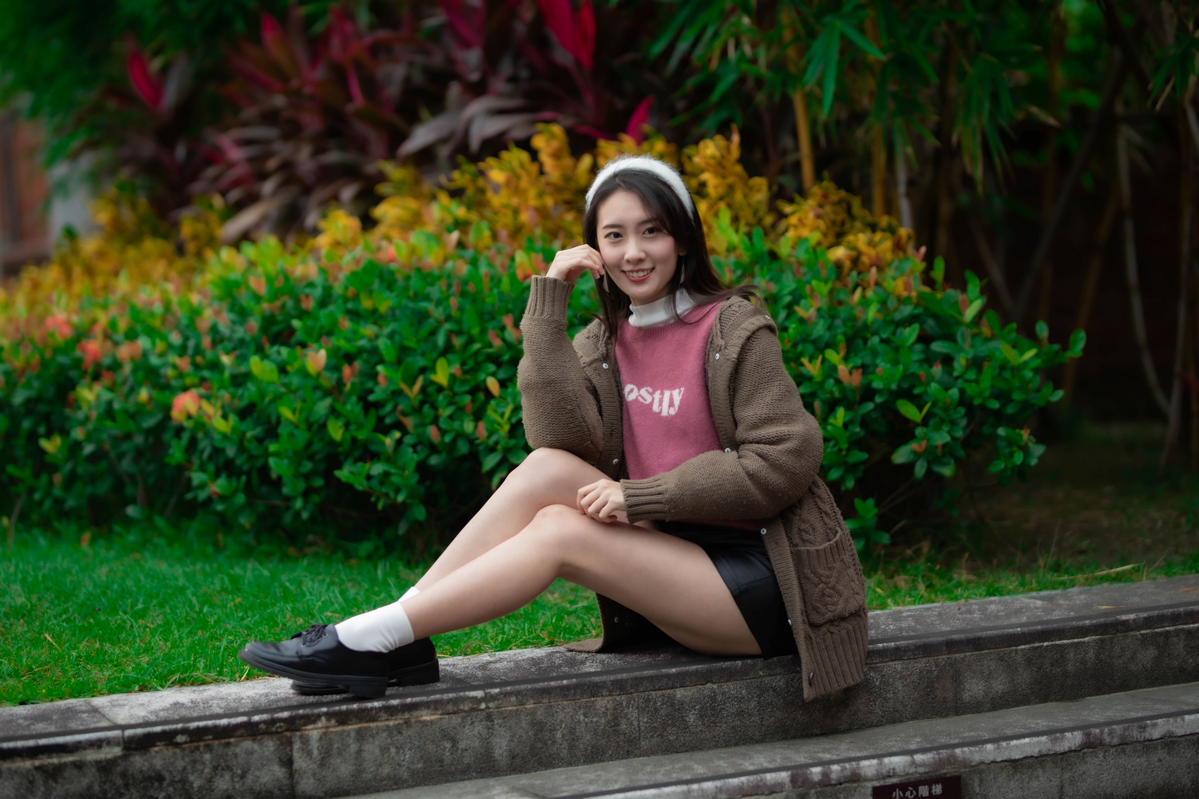 People 3840x2560 Asian model women long hair dark hair sitting socks white socks short socks shoes leather shoes pointed toes women outdoors smiling looking at viewer outdoors hand on face long sleeves depth of field grass
