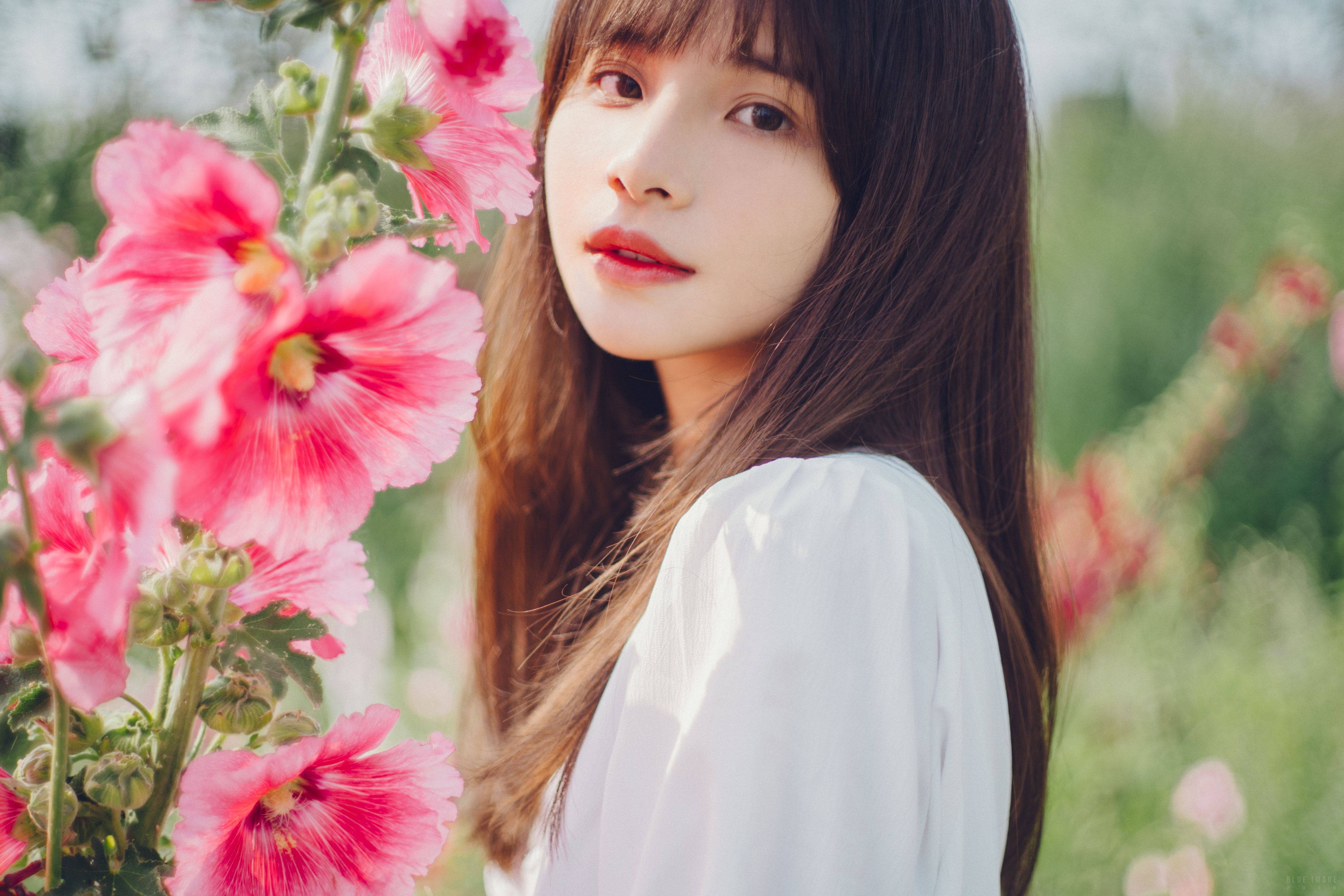 People 3840x2560 women Asian portrait model brunette brown eyes looking at viewer smiling red lipstick bangs long hair dress white clothing bokeh flowers plants depth of field closeup face outdoors women outdoors