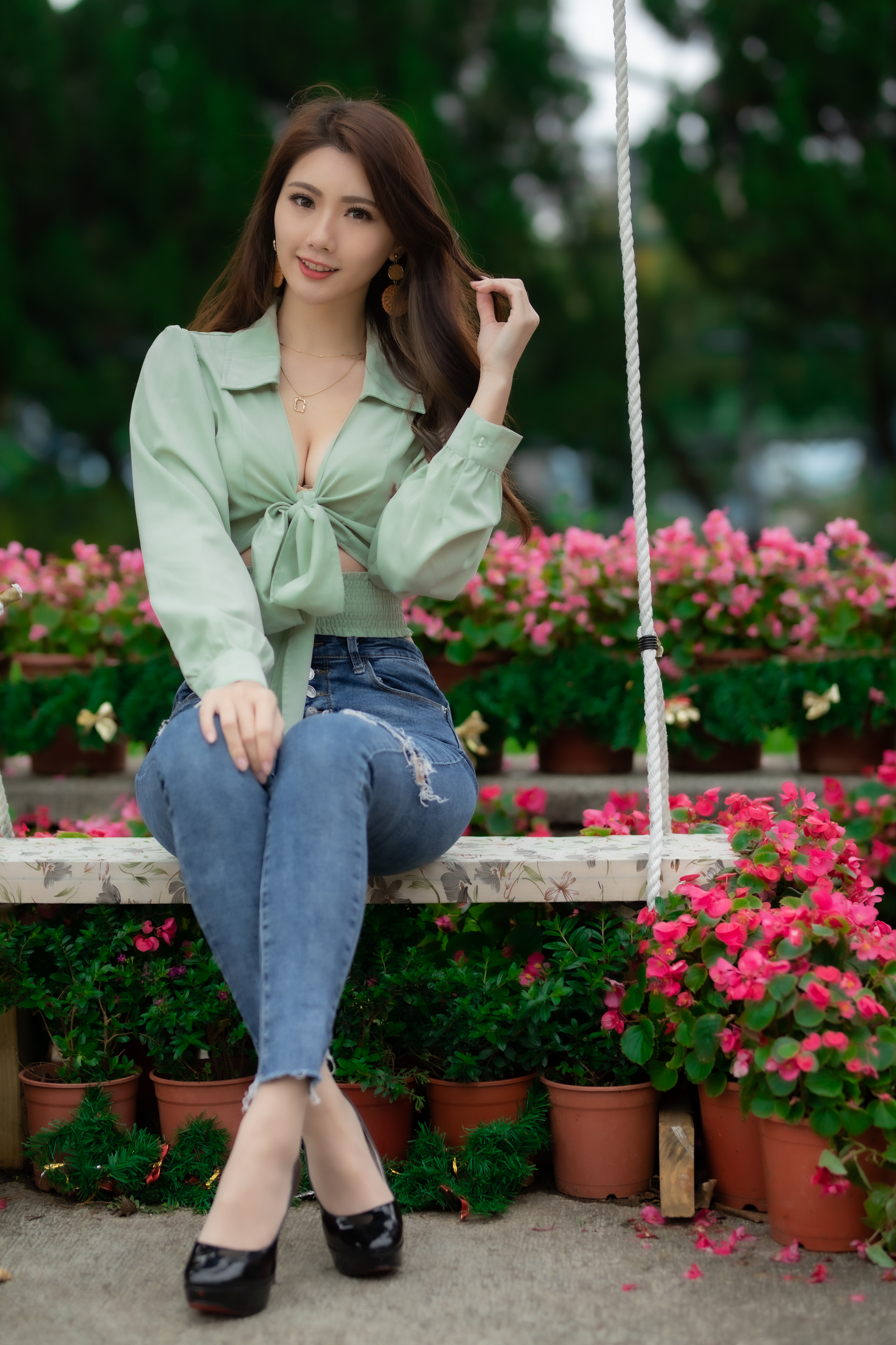 People 2560x3840 Asian model women long hair dark hair depth of field jeans sitting swing blouse black heels flowerpot flowers earring looking at viewer