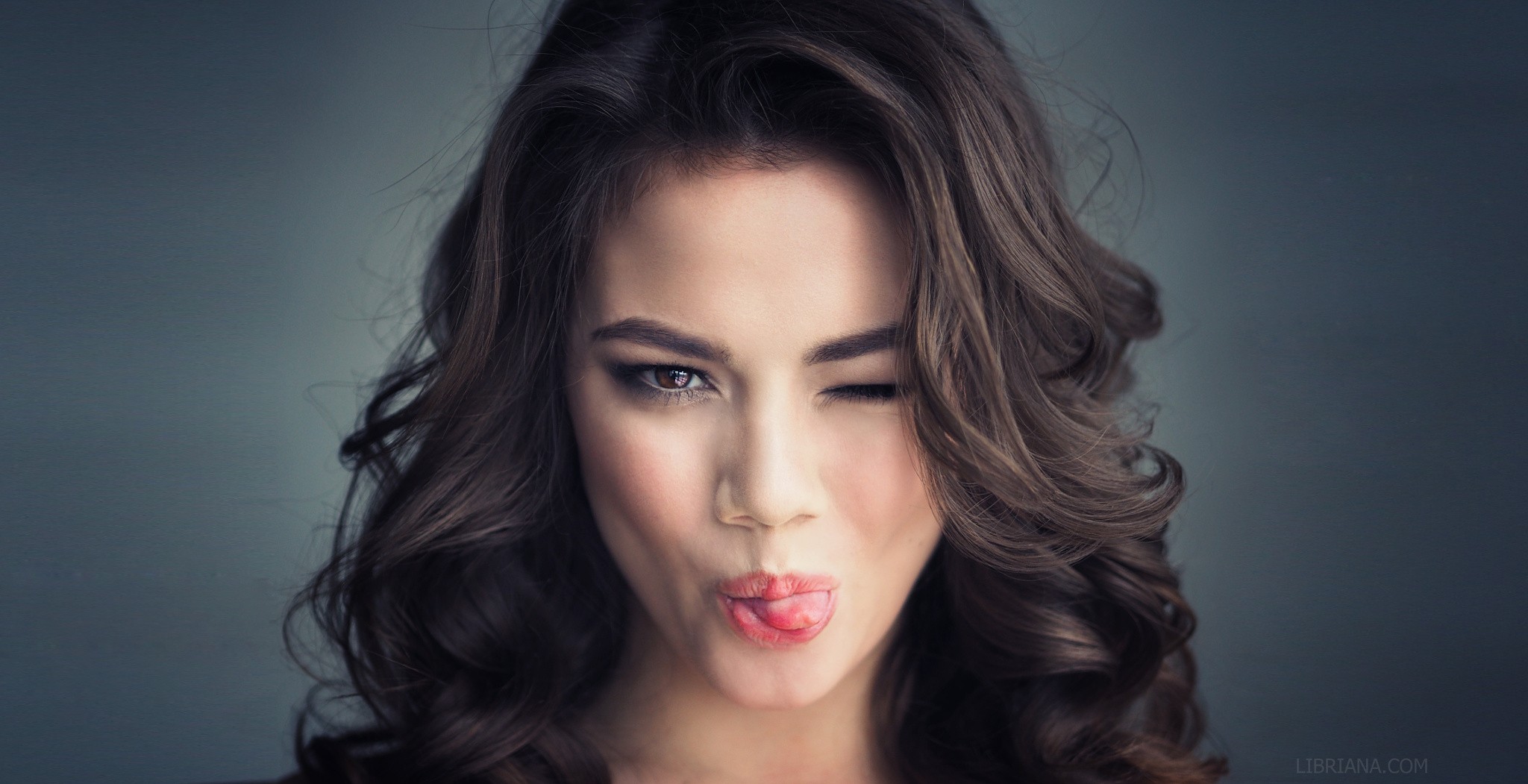 People 2048x1051 women simple background wavy hair face long hair brunette model brown eyes tongues looking at viewer women indoors indoors tongue out watermarked Libriana studio one eye closed
