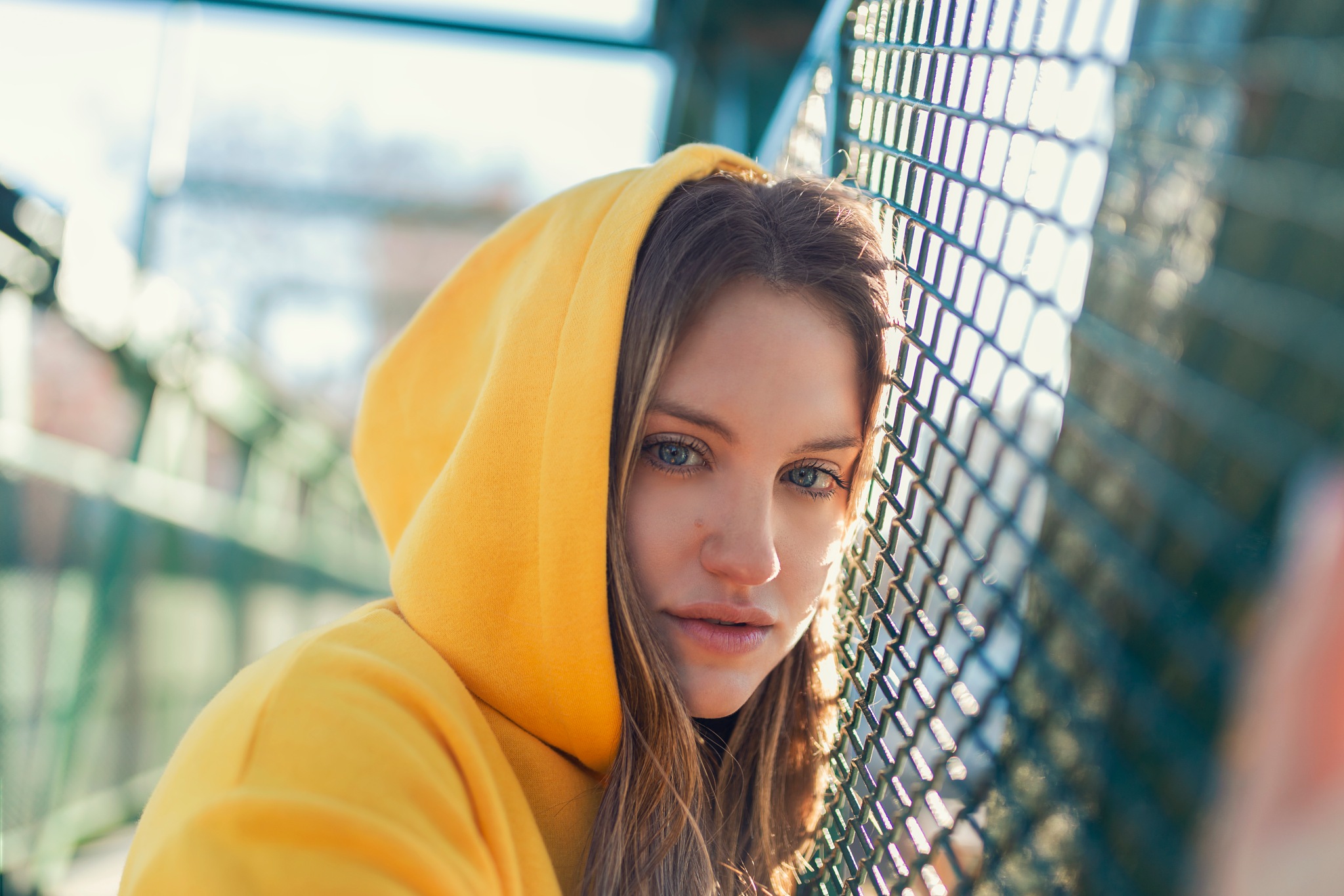 People 2048x1365 women model portrait blonde blue eyes looking at viewer open mouth hoods yellow shirt fence depth of field Mariano Felchle