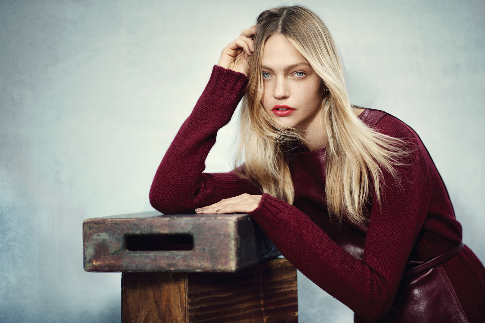 People 2048x1364 Sasha Pivovarova model actress women blonde red lipstick looking at viewer dyed hair red sweater gray eyes sweater one arm up arm support touching hair simple background