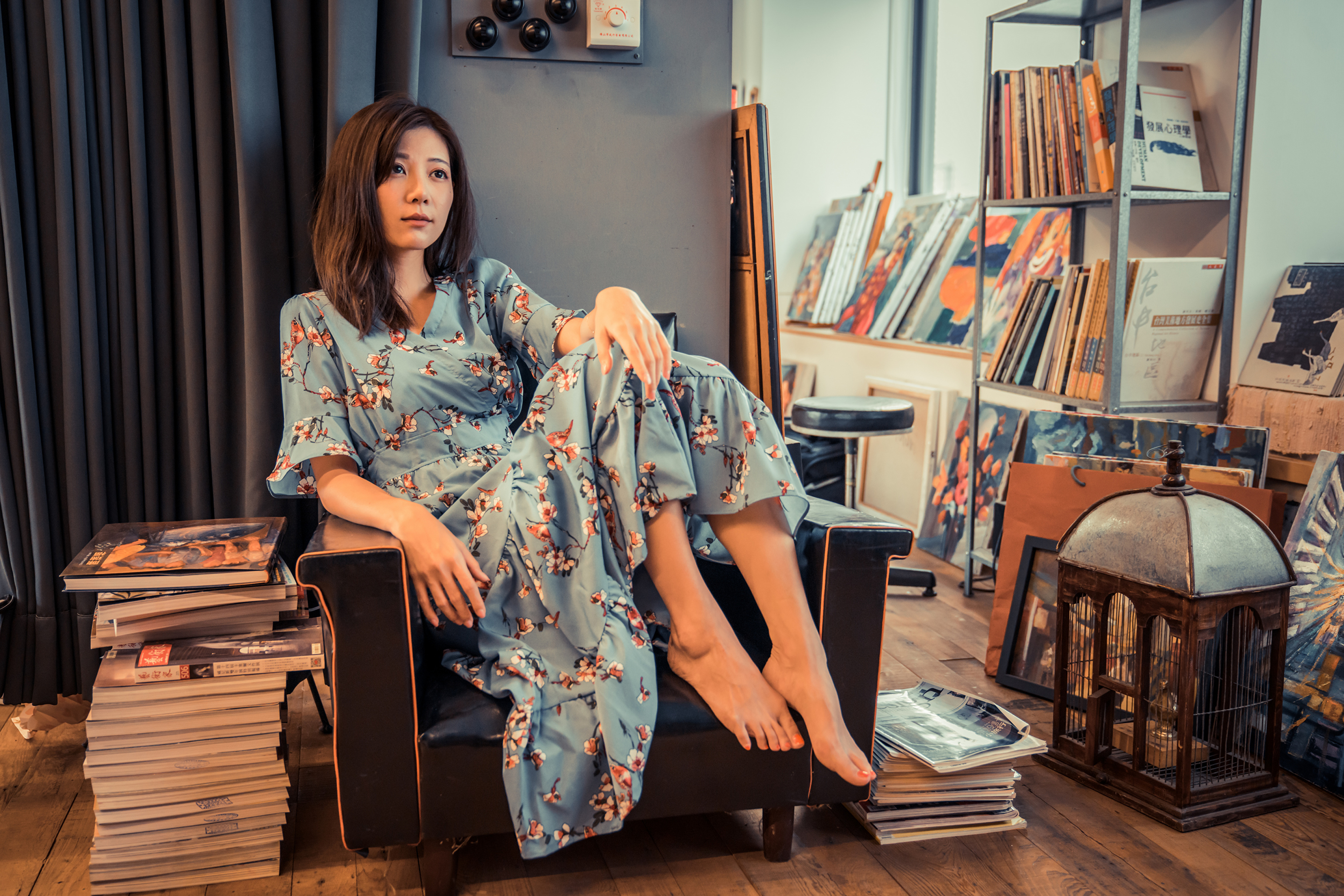 People 3840x2561 Asian model women long hair dark hair depth of field sitting barefoot flower dress chair books magazine shelves painting curtains cages