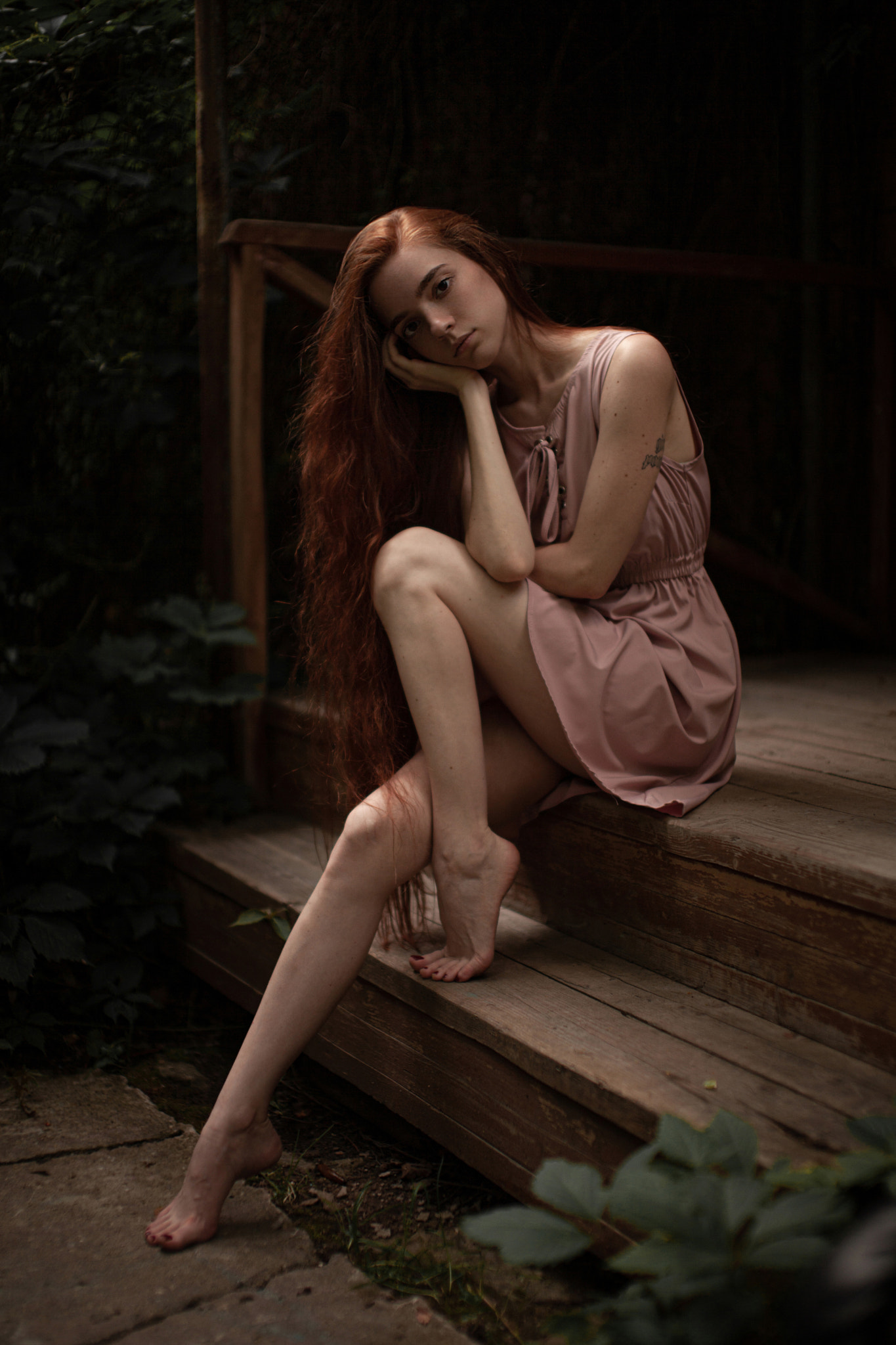 People 1365x2048 Andrey Frolov women redhead long hair resting head dress pink clothing tattoo legs barefoot stairs plants sitting tiptoe thick eyebrows bent legs pink dress model women outdoors portrait display low light