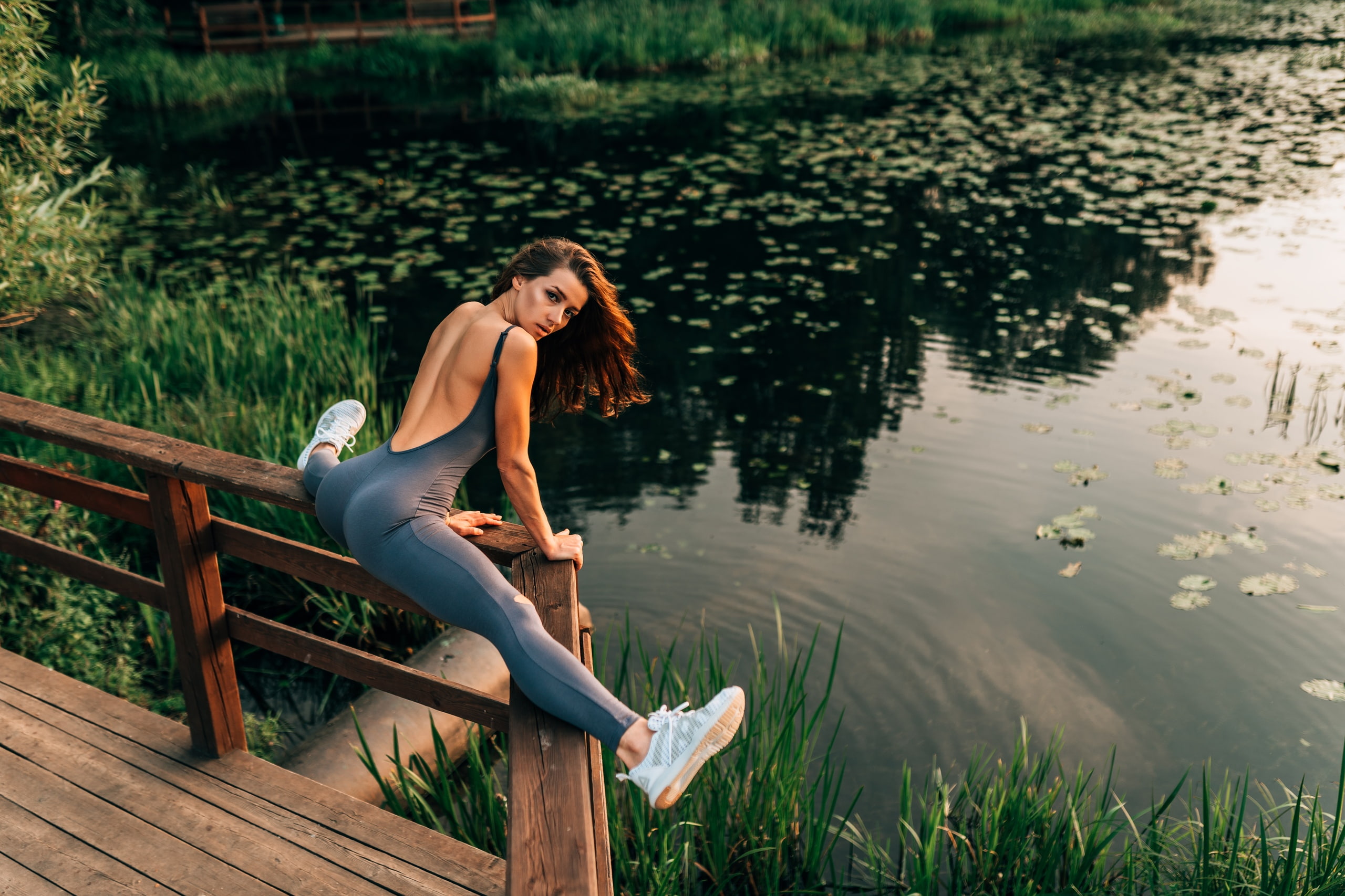 People 2560x1707 women fence brunette sportswear flexible sneakers ass water lake women outdoors looking at viewer eyeliner tight clothing splits looking over shoulder fitness model high angle