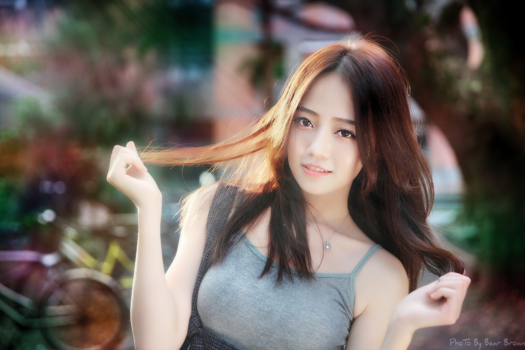 People 2048x1365 women grey tops sun rays Asian model hair pulling necklace brunette face looking at viewer outdoors women outdoors watermarked dyed hair Chinese women collarbone long hair holding hair bare shoulders blurred blurry background teeth sunlight