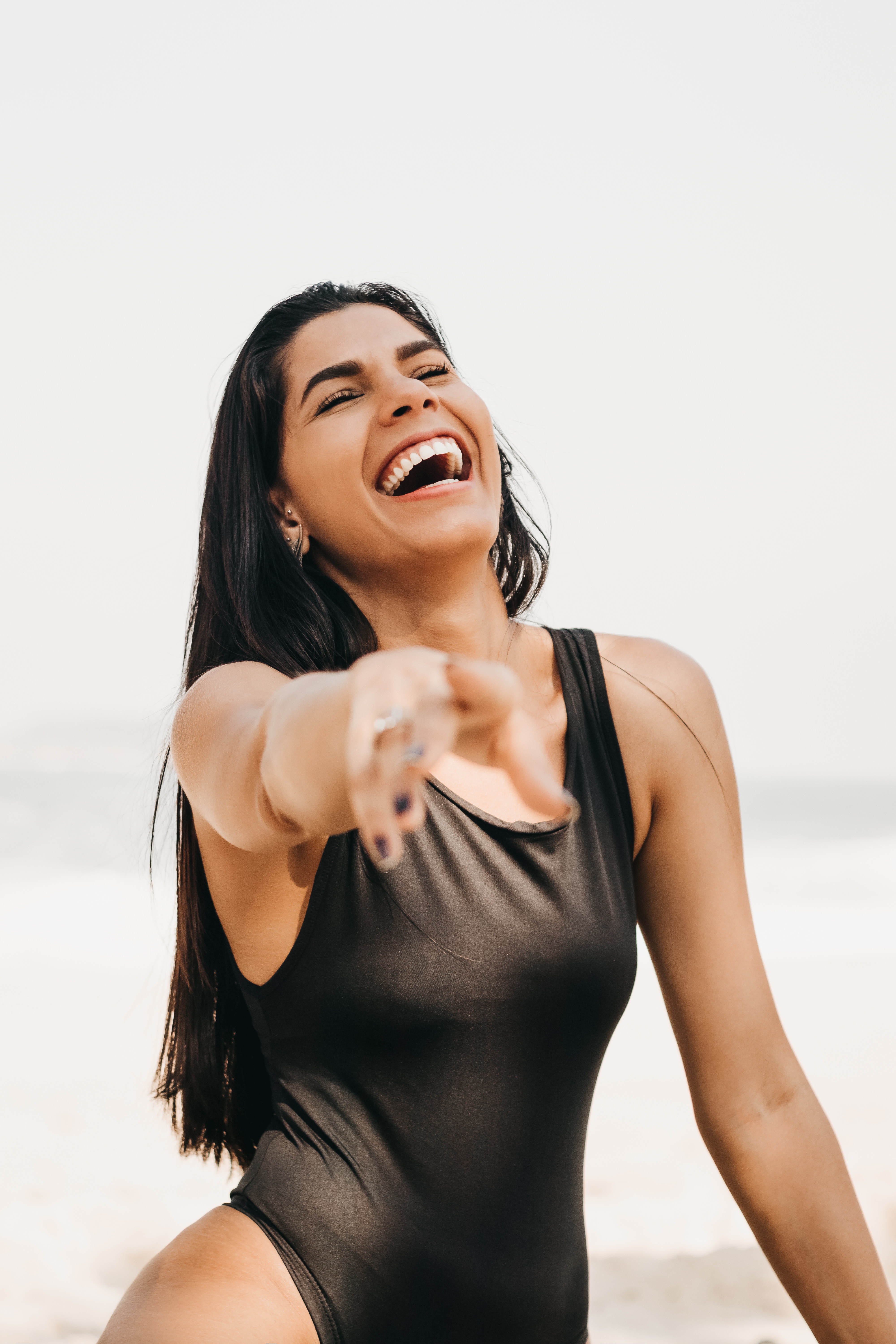 People 4000x6000 happy one-piece swimsuit laughing finger pointing giggling portrait display simple background women open mouth closed eyes teeth long hair ear piercing