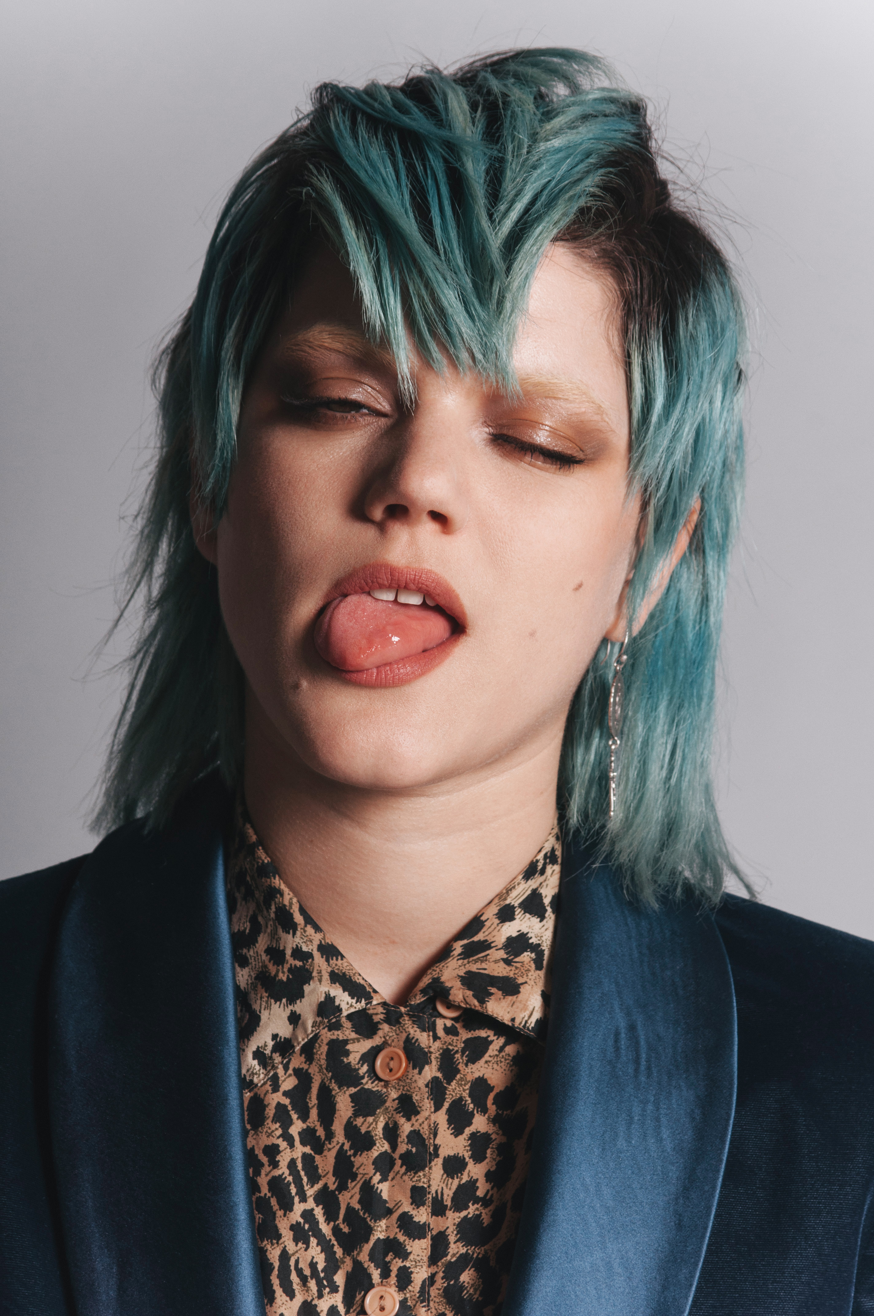 People 2848x4288 SoKo singer women simple background portrait display closeup one eye closed tongues tongue out teeth looking at viewer earring hair between eyes vest shoulder length hair face short hair two tone hair